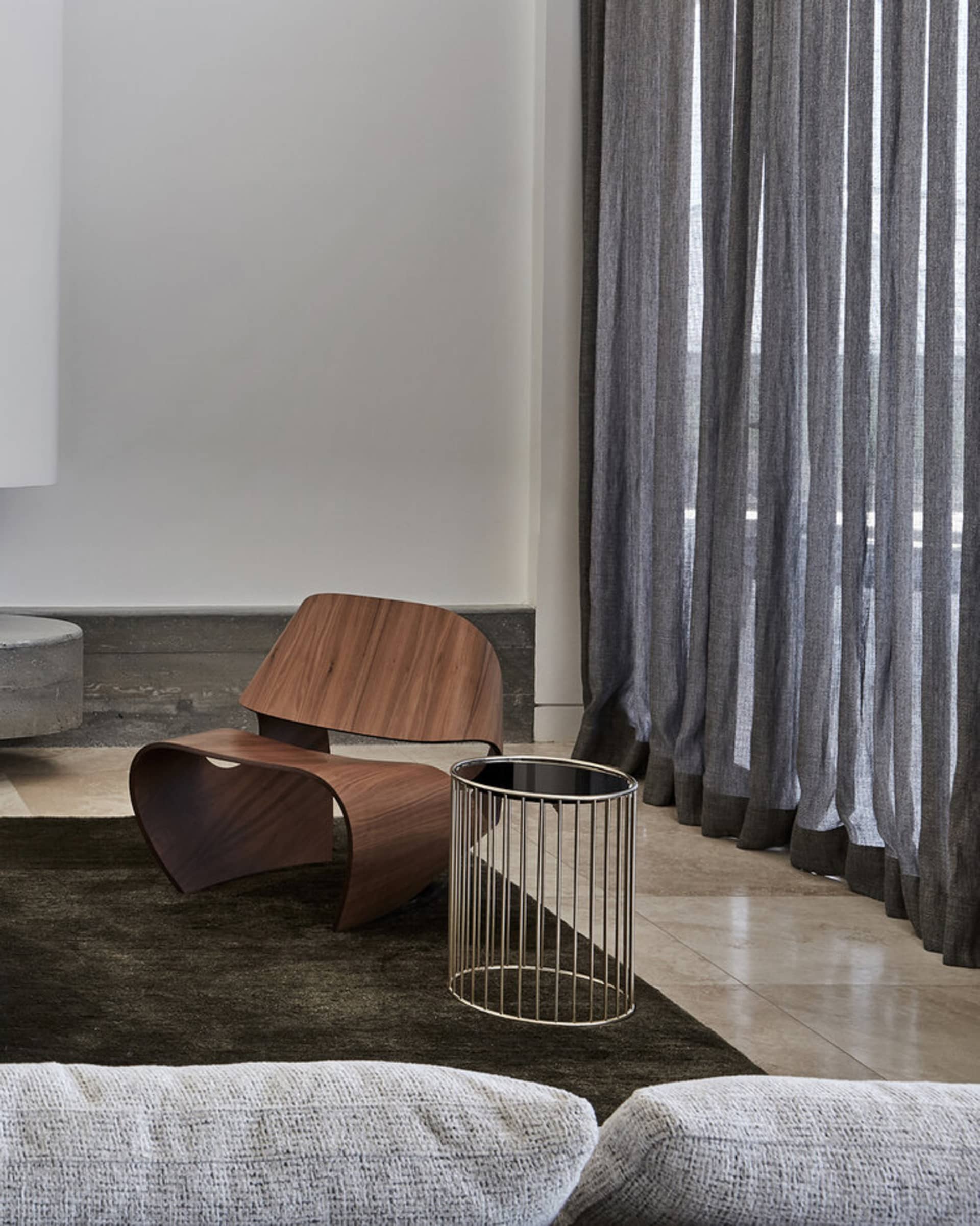 A modern living room featuring a wooden armchair and a metal side table.