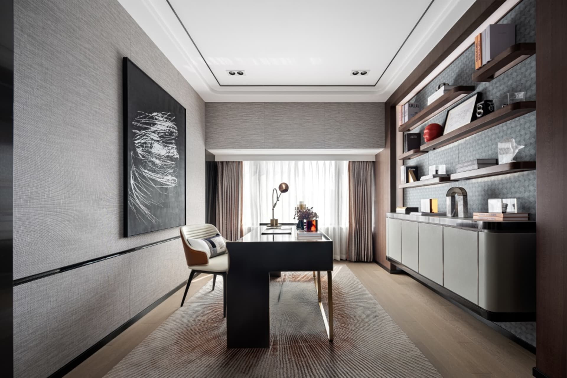 Modern office featuring a wooden desk, fabric chair, metal shelving, and abstract wall art.