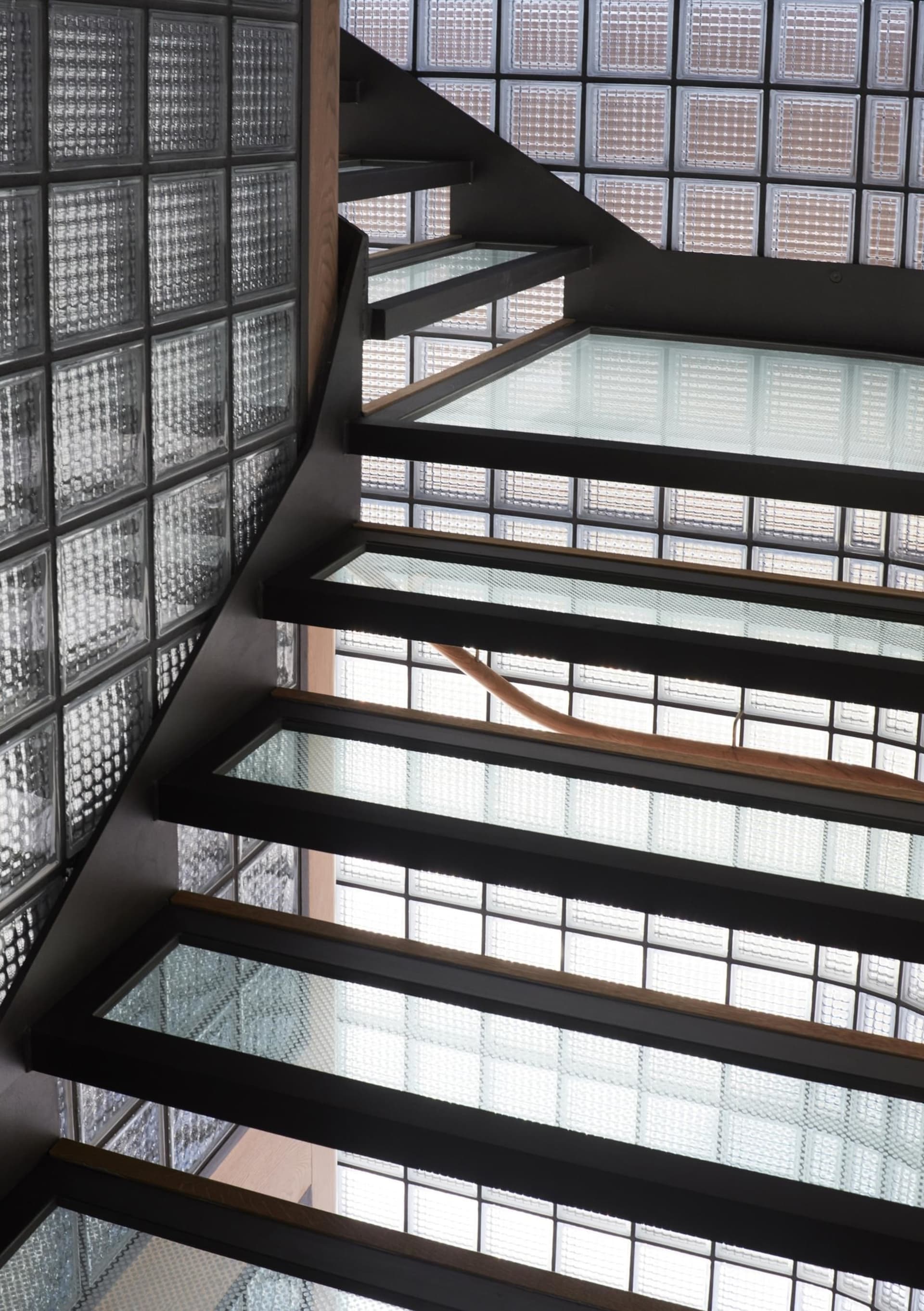 An industrial-style staircase with glass blocks and metal railings.