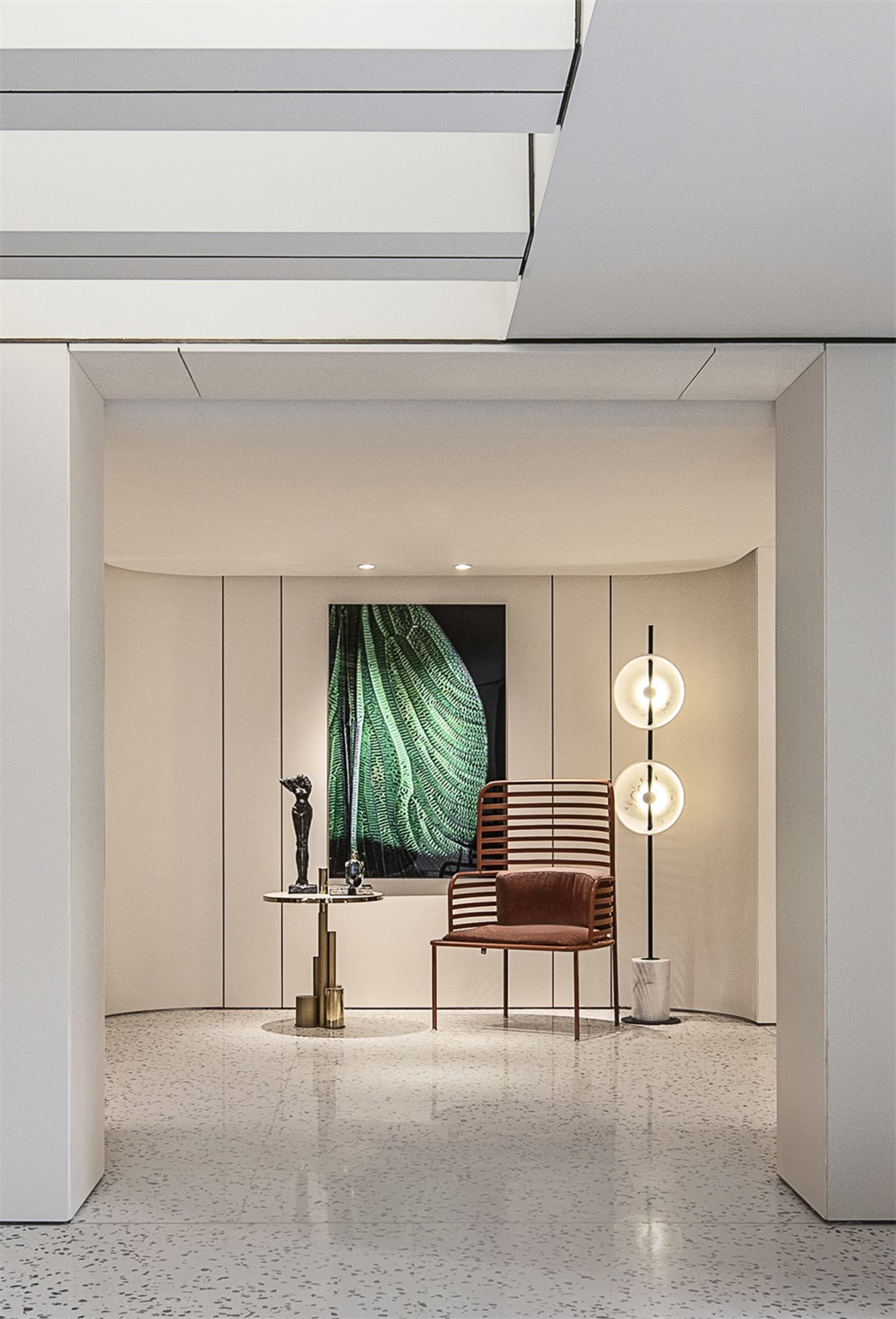 A modern, metallic entryway featuring minimalist design elements and a vibrant, abstract painting.