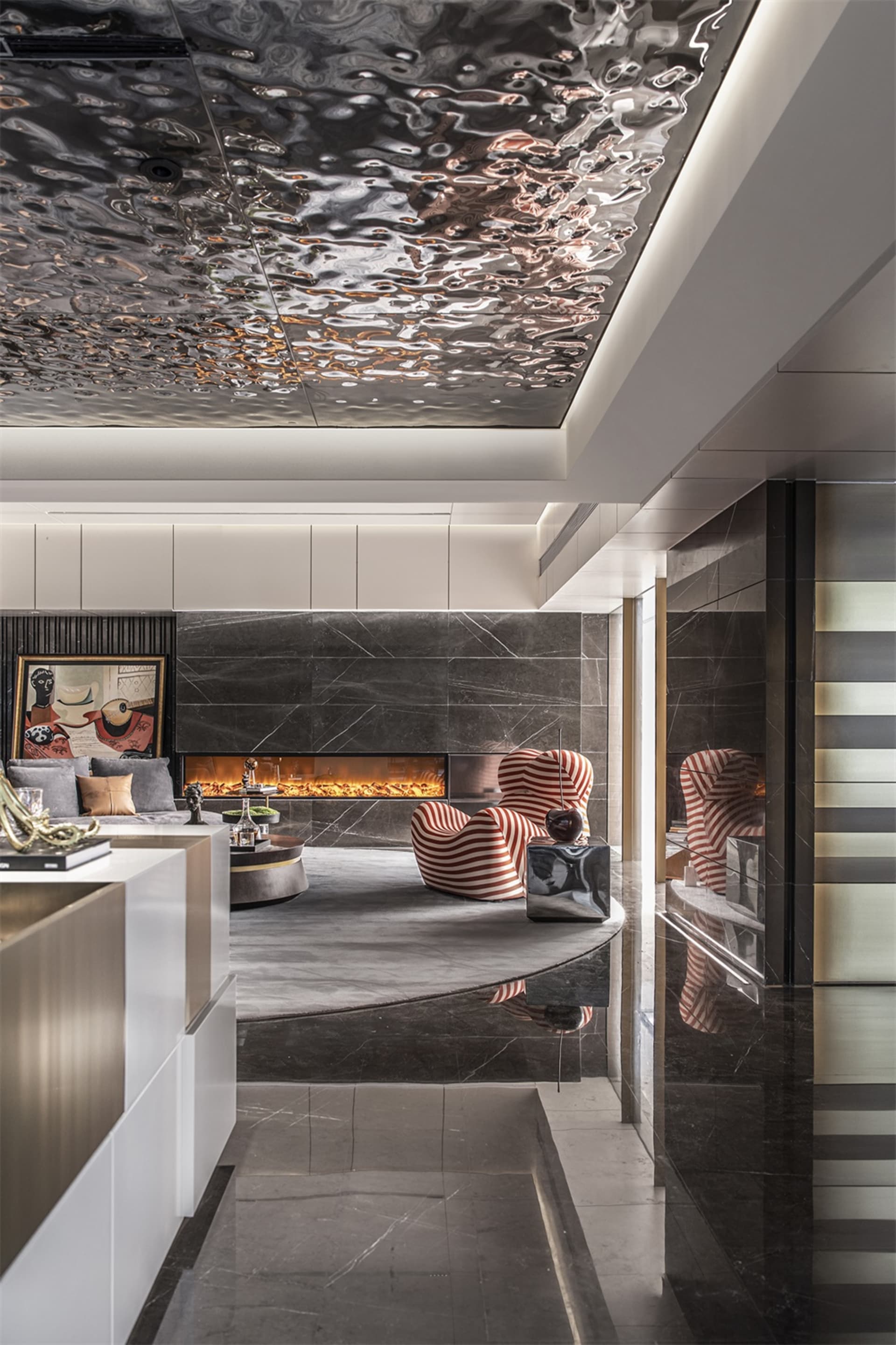 Modern living room with metallic tiles, marble fireplace, and striped armchairs.