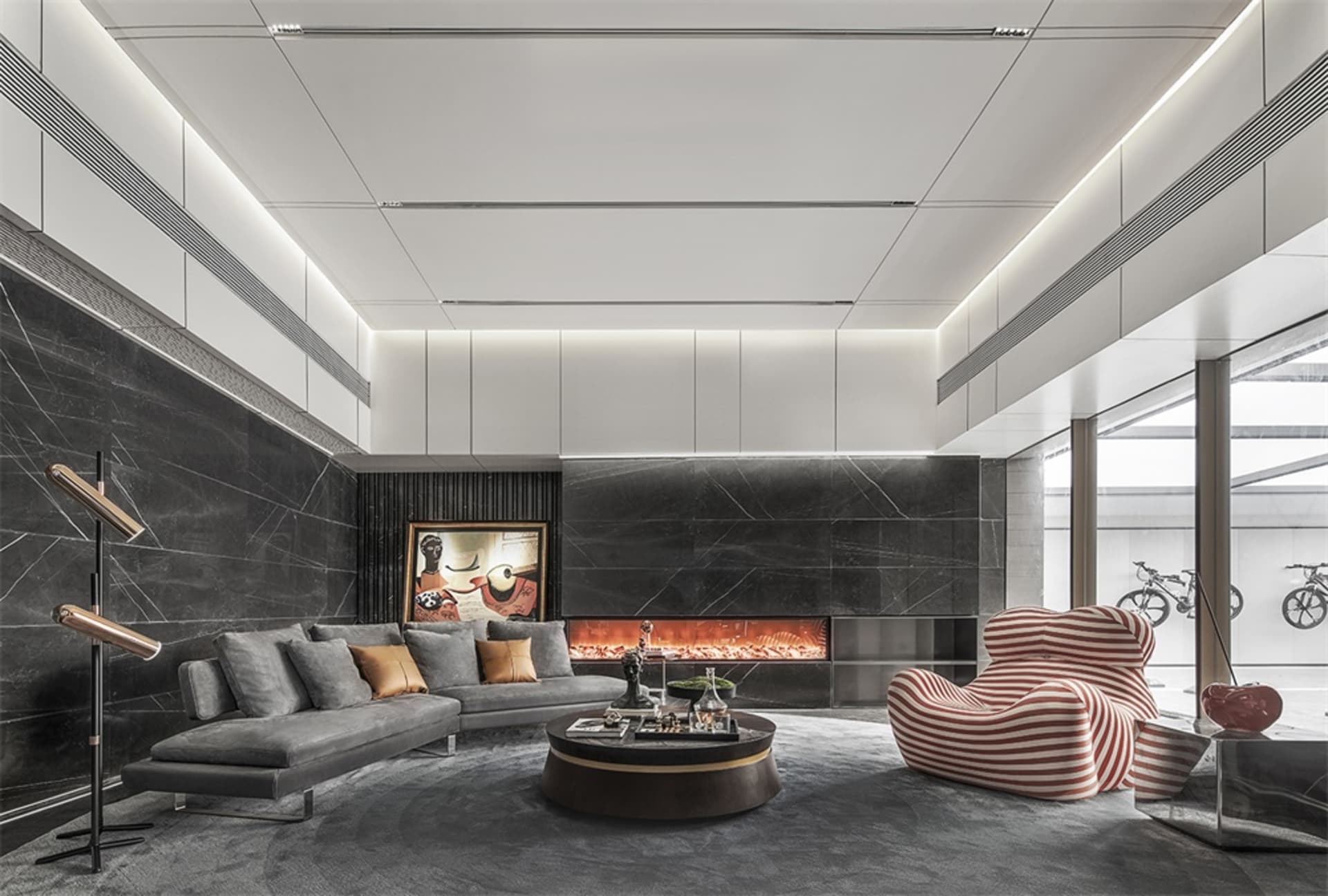 A modern minimalist living room with marble walls and a comfortable seating area.