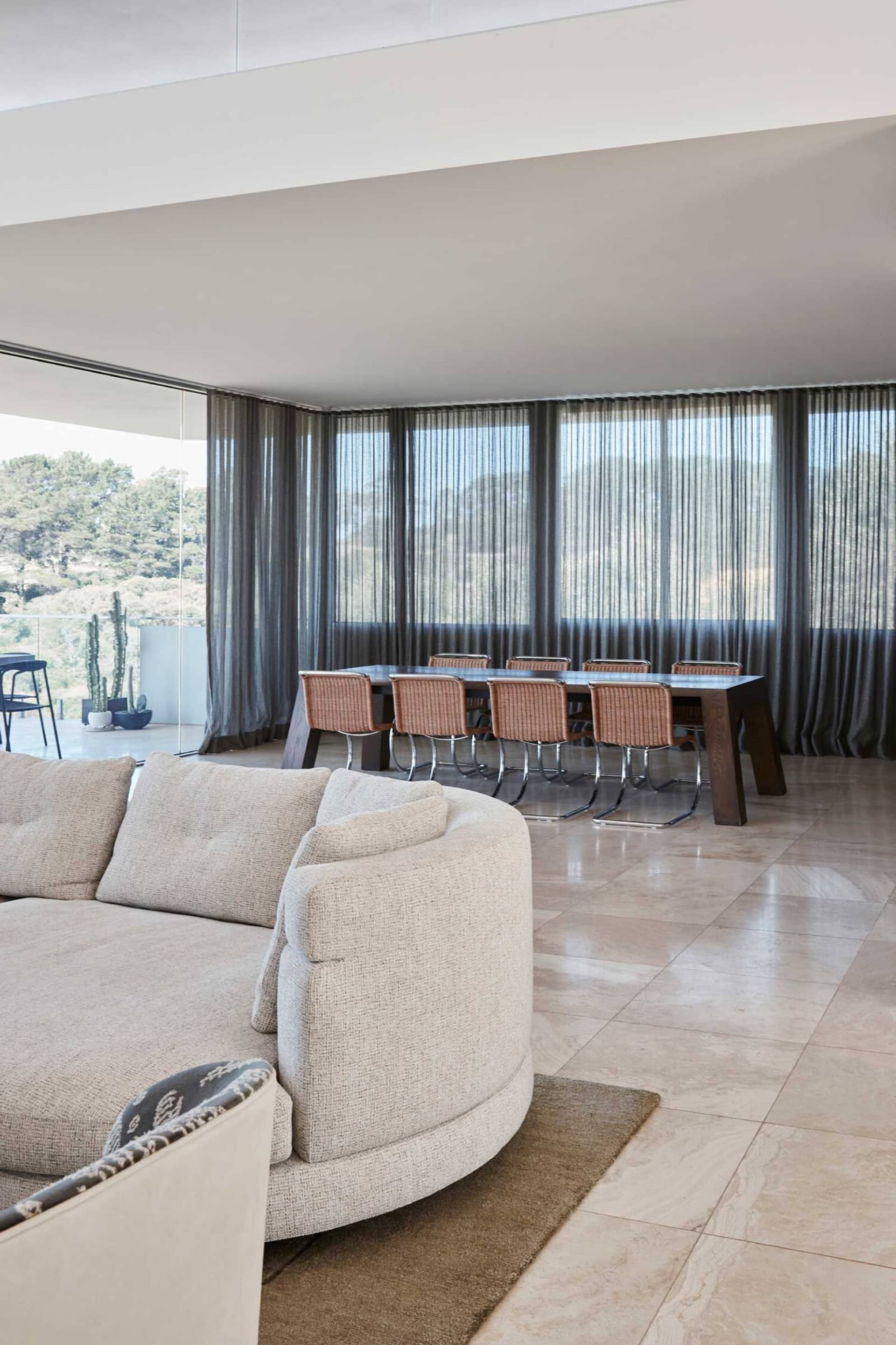 Modern sofa with fabric cushions on a polished marble floor in a residential interior setting.