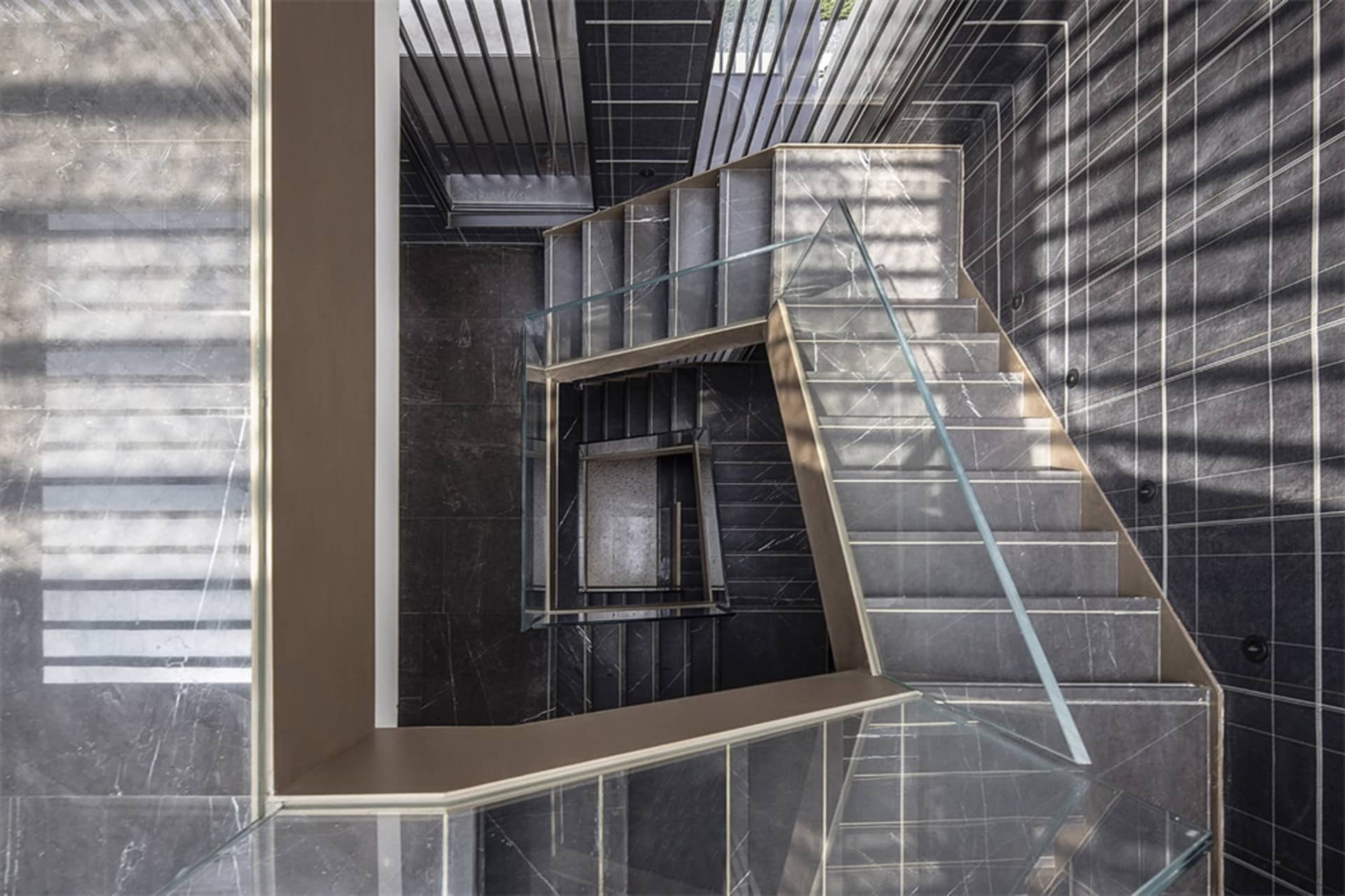 Modern staircase with concrete steps and glass railing