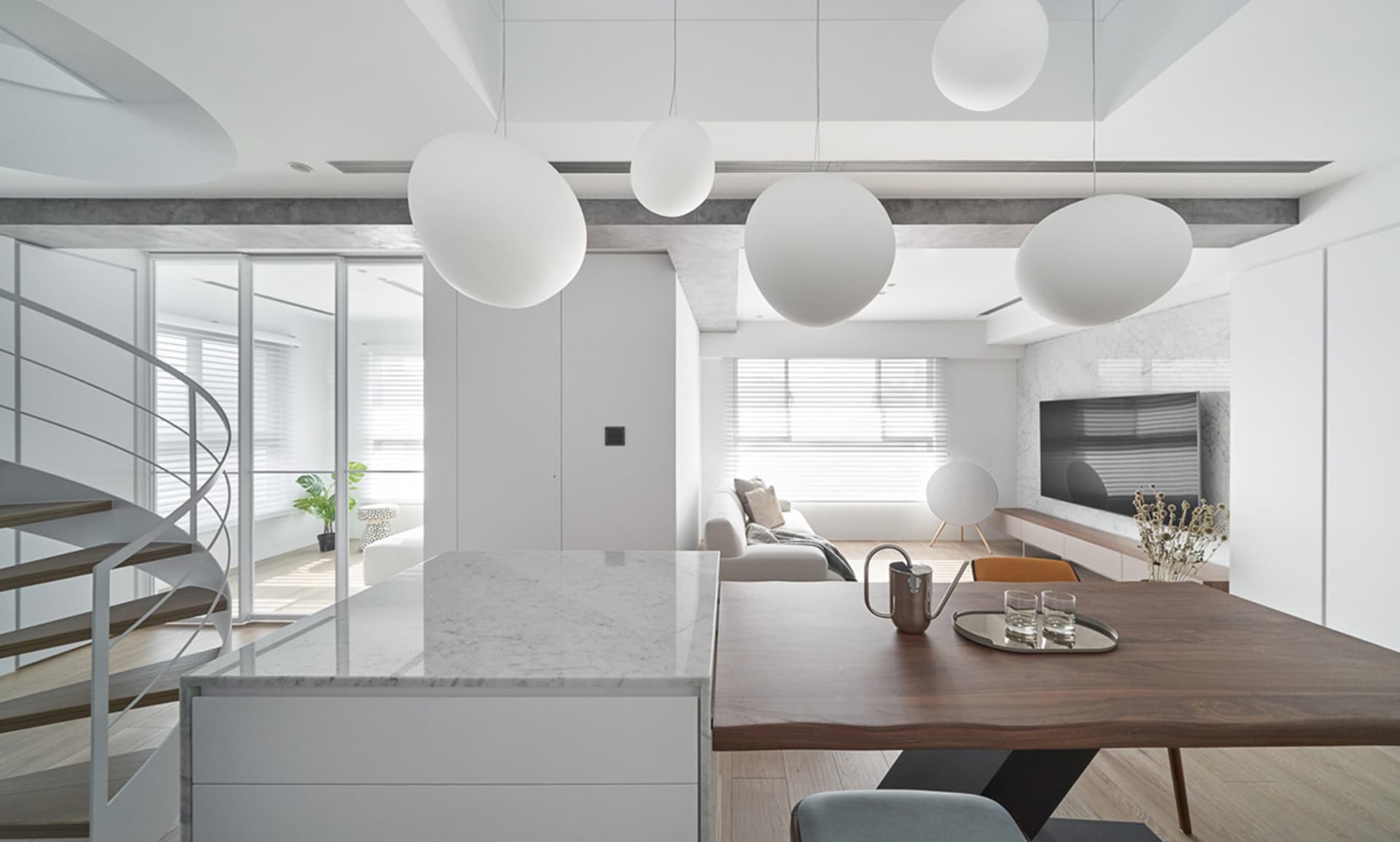 A modern apartment featuring a marble kitchen island and a living room with concrete walls and canvas seating.