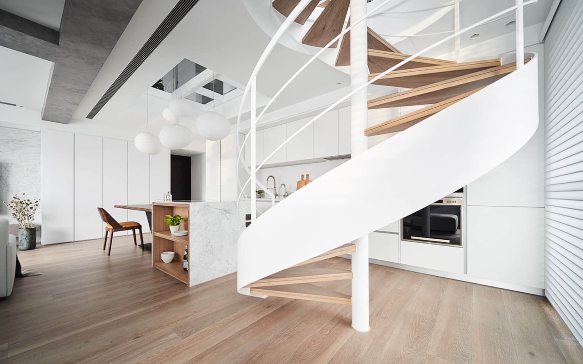 Modern kitchen featuring marble countertops and wooden stairs and boardwalk.