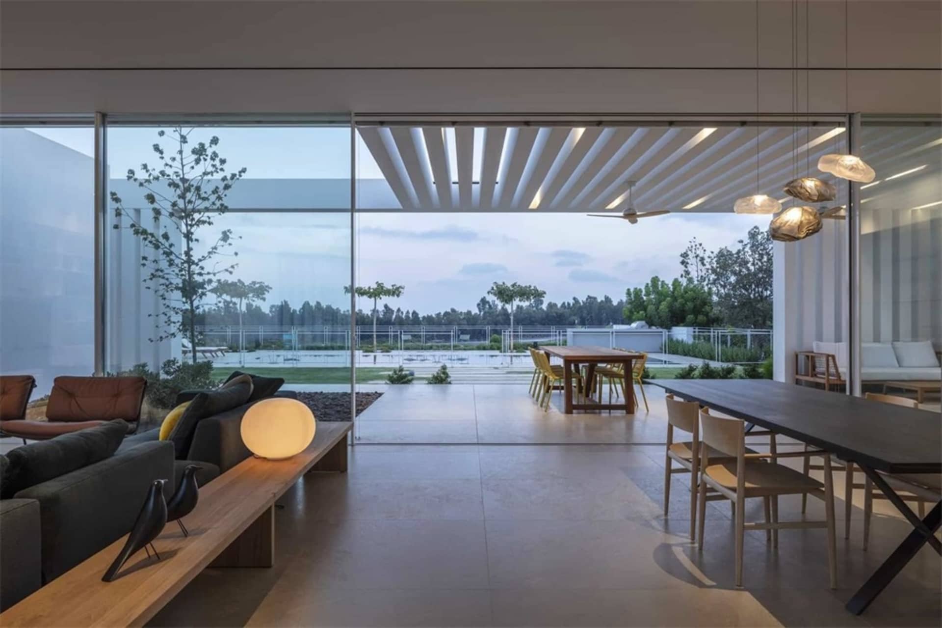 現代客廳兼餐廳,採用混凝土地板與大型玻璃窗。
