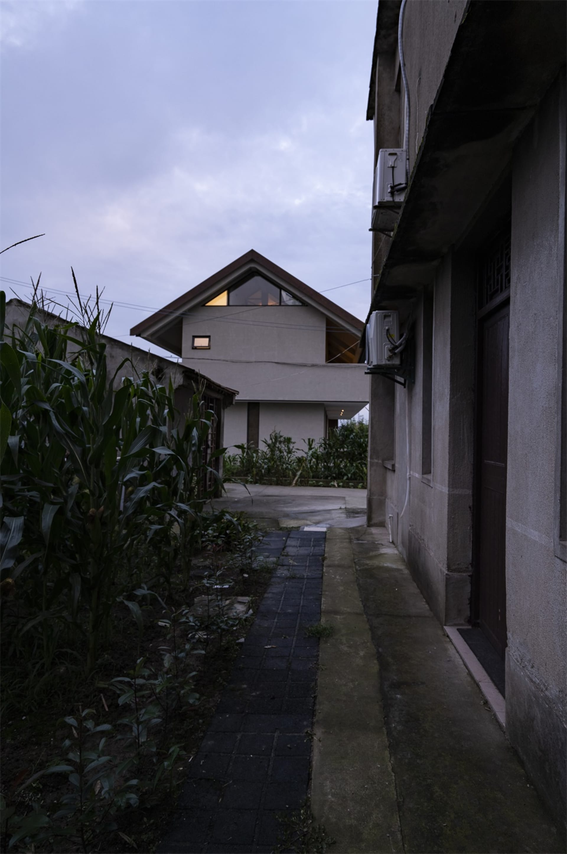 Modern residential exterior featuring a concrete fence and garden