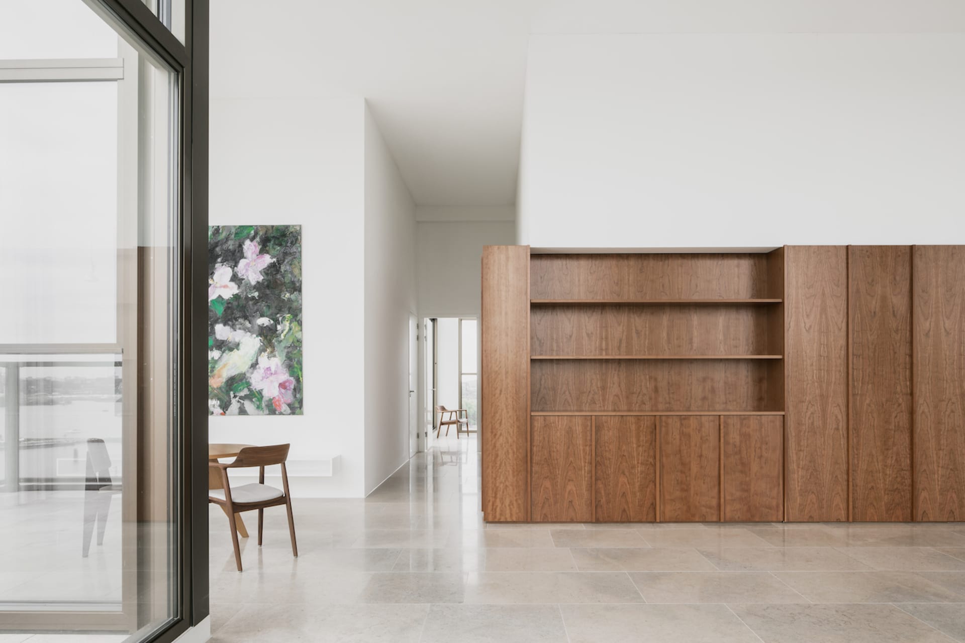 A modern residential living room with wood, glass, and marble features.
