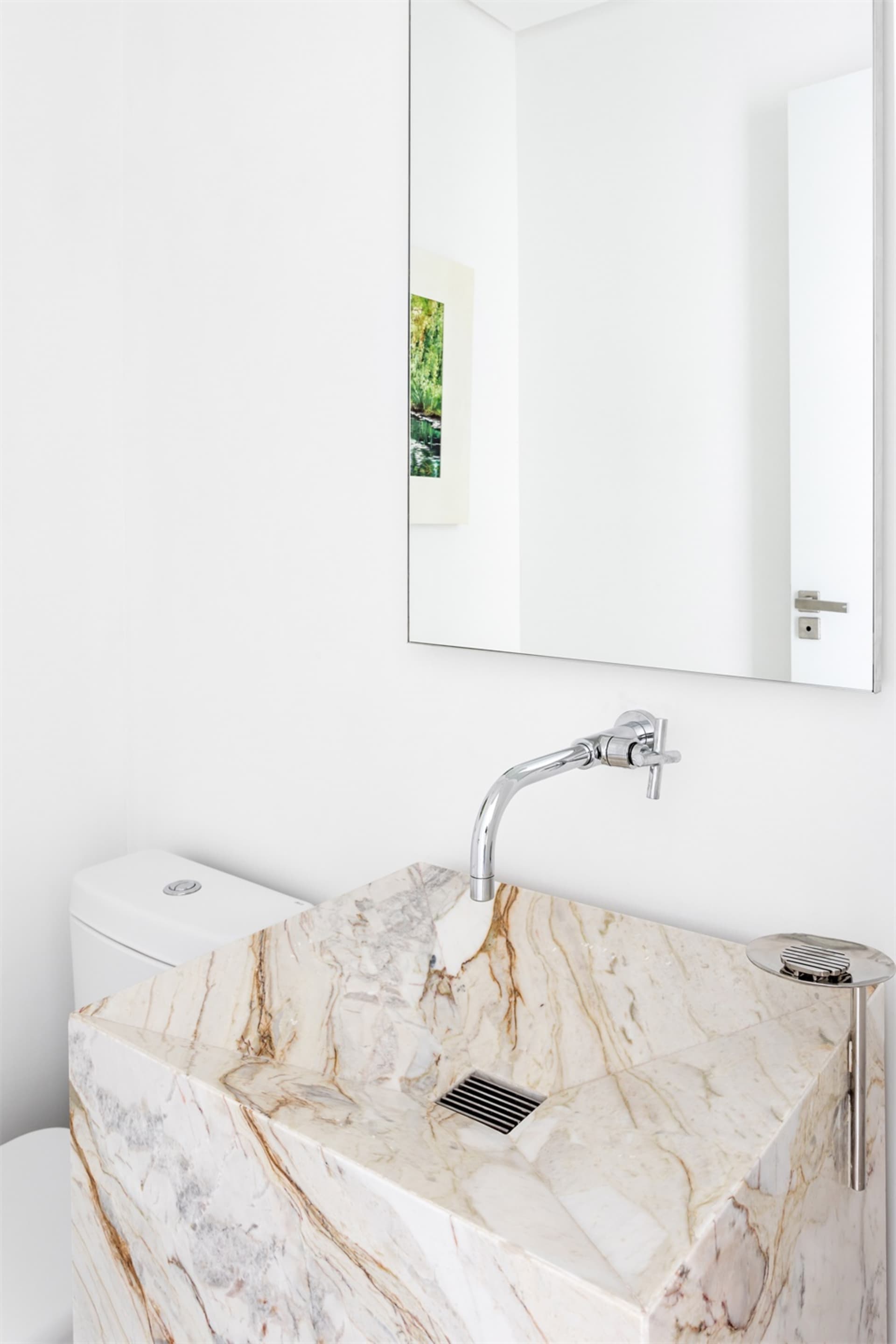 A contemporary white marble bathroom featuring a square sink and a minimalist design.