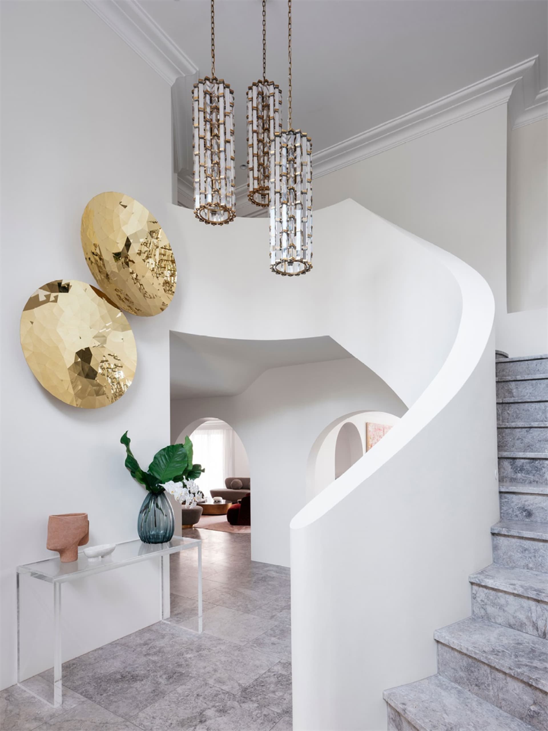 Modern staircase with marble and cement materials and a glass console table.