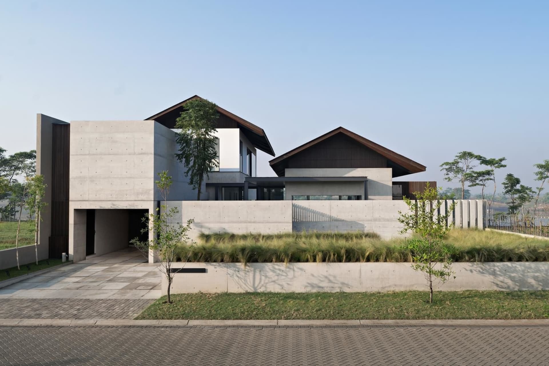 A modern residential home with a concrete exterior and a garage entrance.