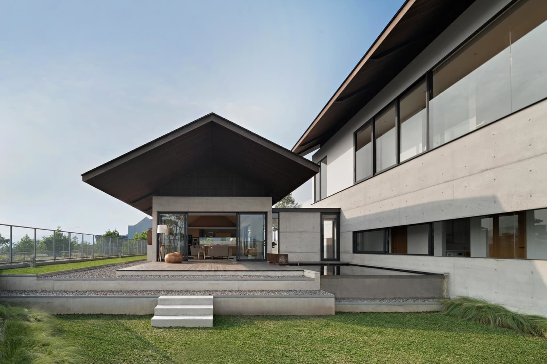 Modern residential house exterior with concrete and glass materials.