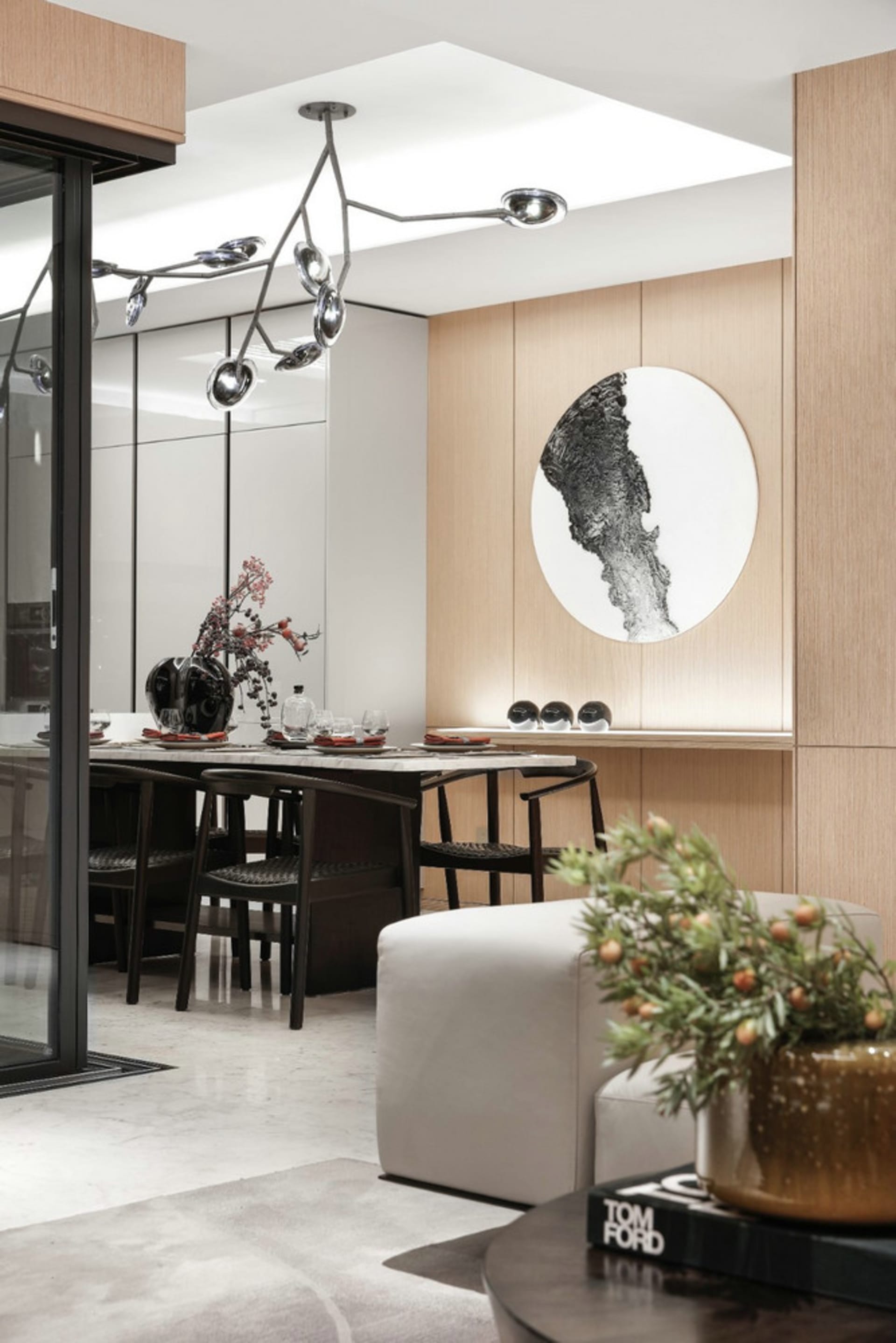 現代餐廳搭配木質板牆,餐桌已擺設晚餐餐具,牆上掛著一幅大型抽象畫。