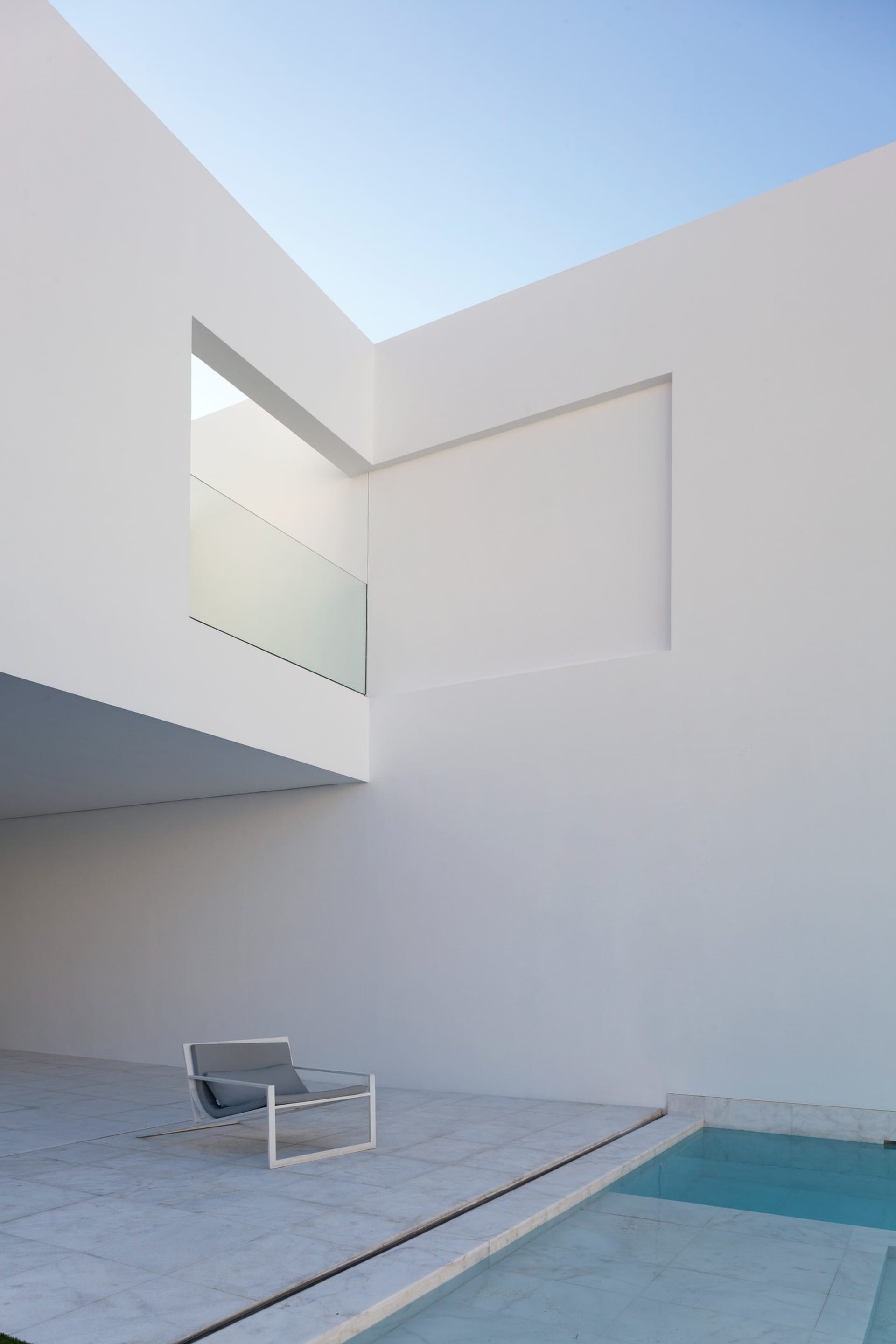 Concrete patio area with minimalistic design and a pool