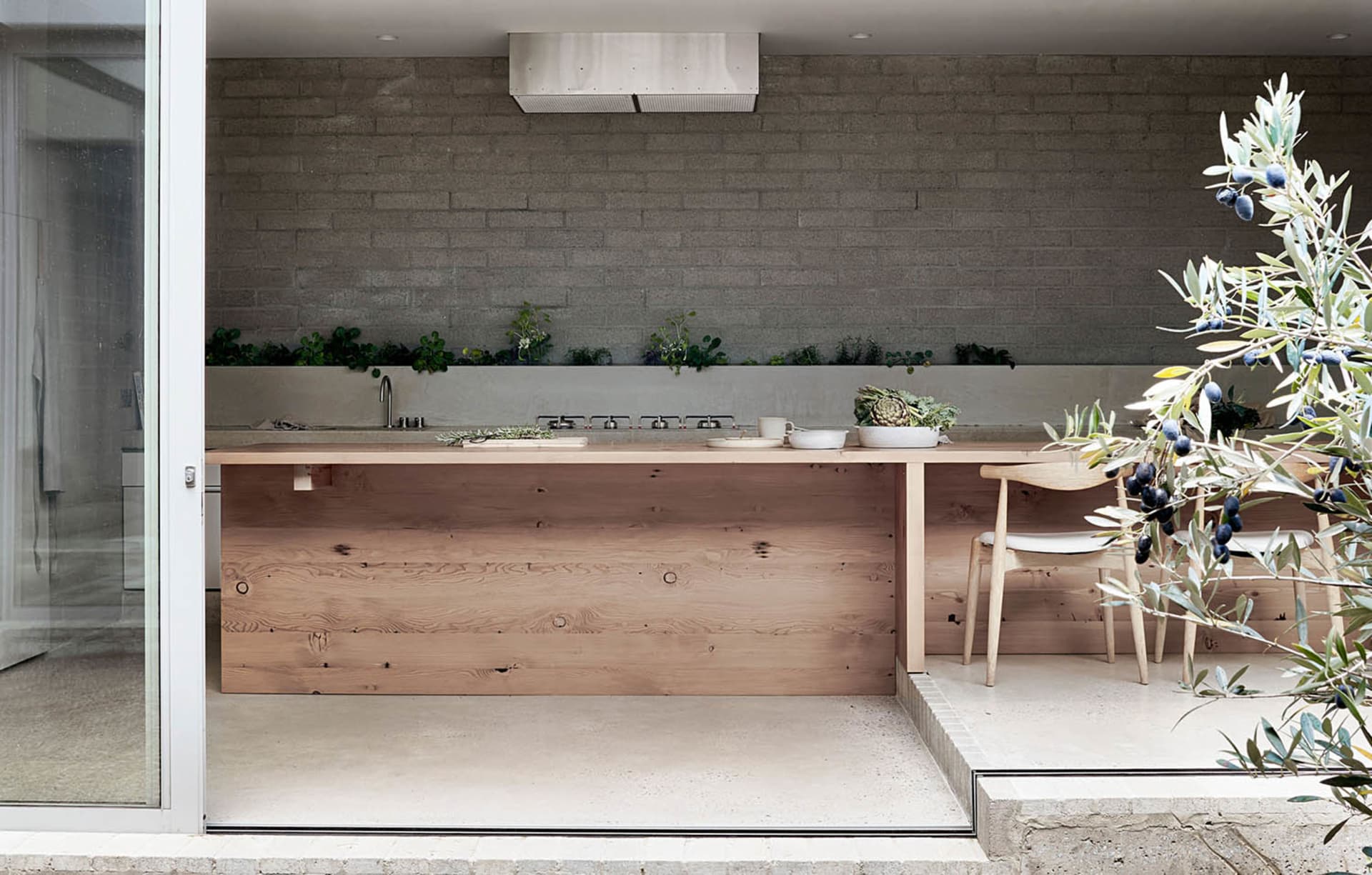 A contemporary kitchen with minimalist design featuring wooden finishes and a sleek, uncluttered layout.