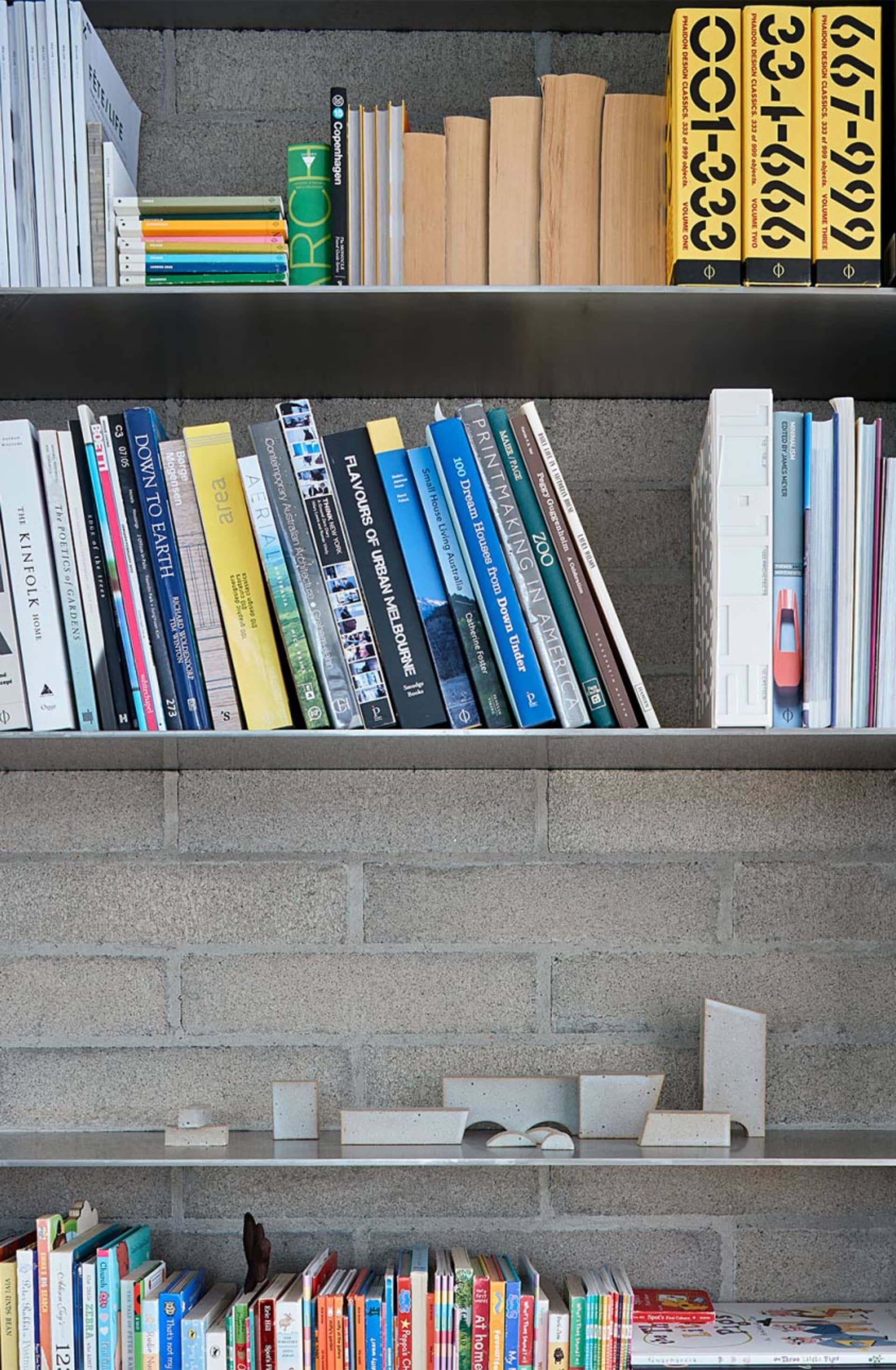 Modern concrete bookshelf displaying organized books.
