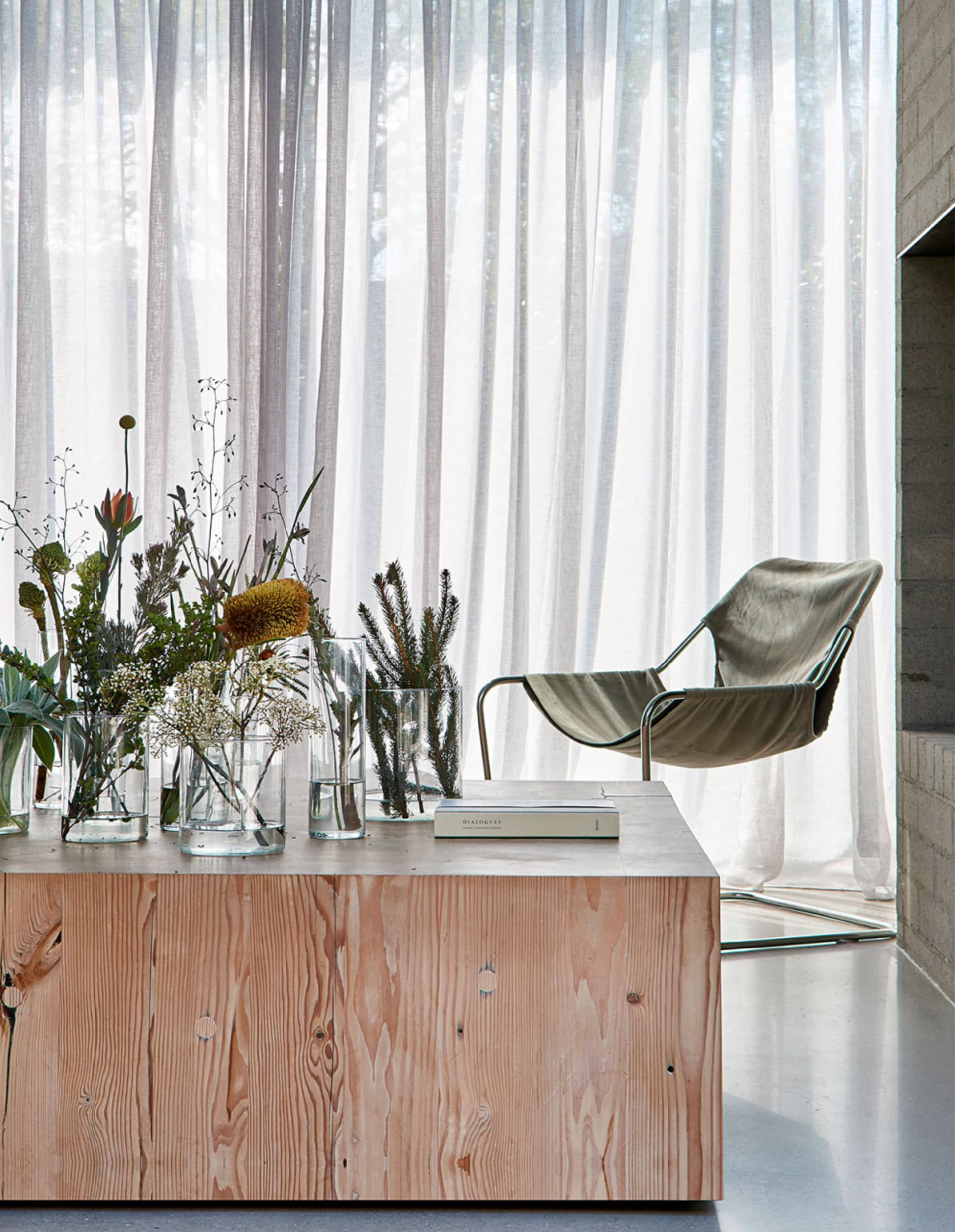 A modern living space featuring transparent glass and wooden furniture.