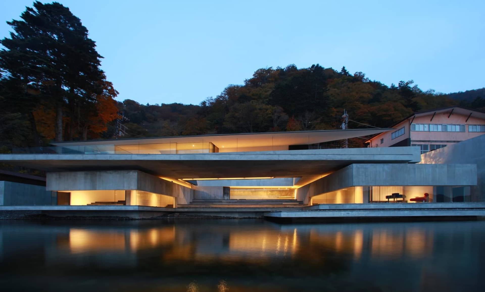 A modern residential house featuring concrete and glass materials.