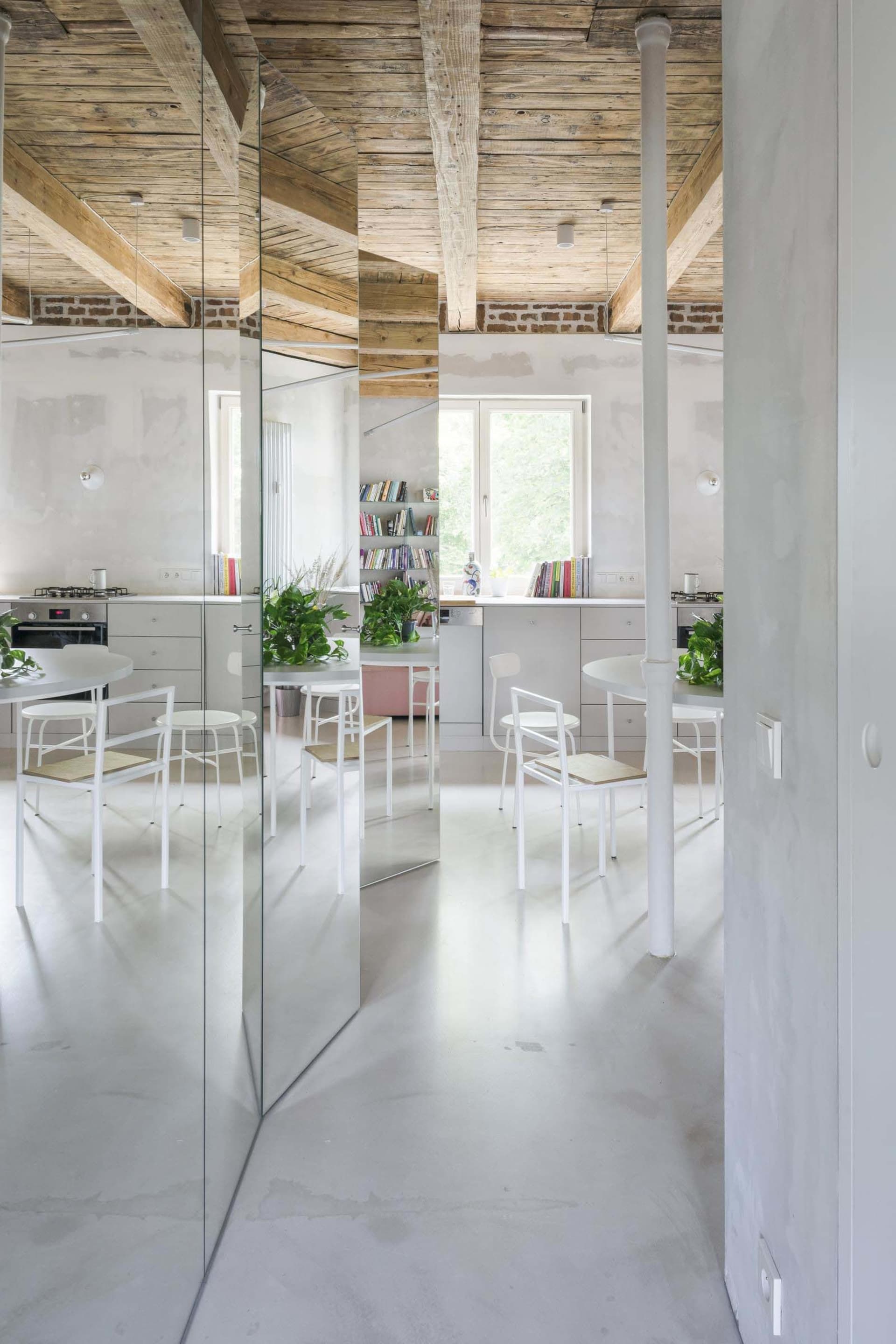 A minimalist industrial kitchen with a white concrete ceiling and modern furniture.