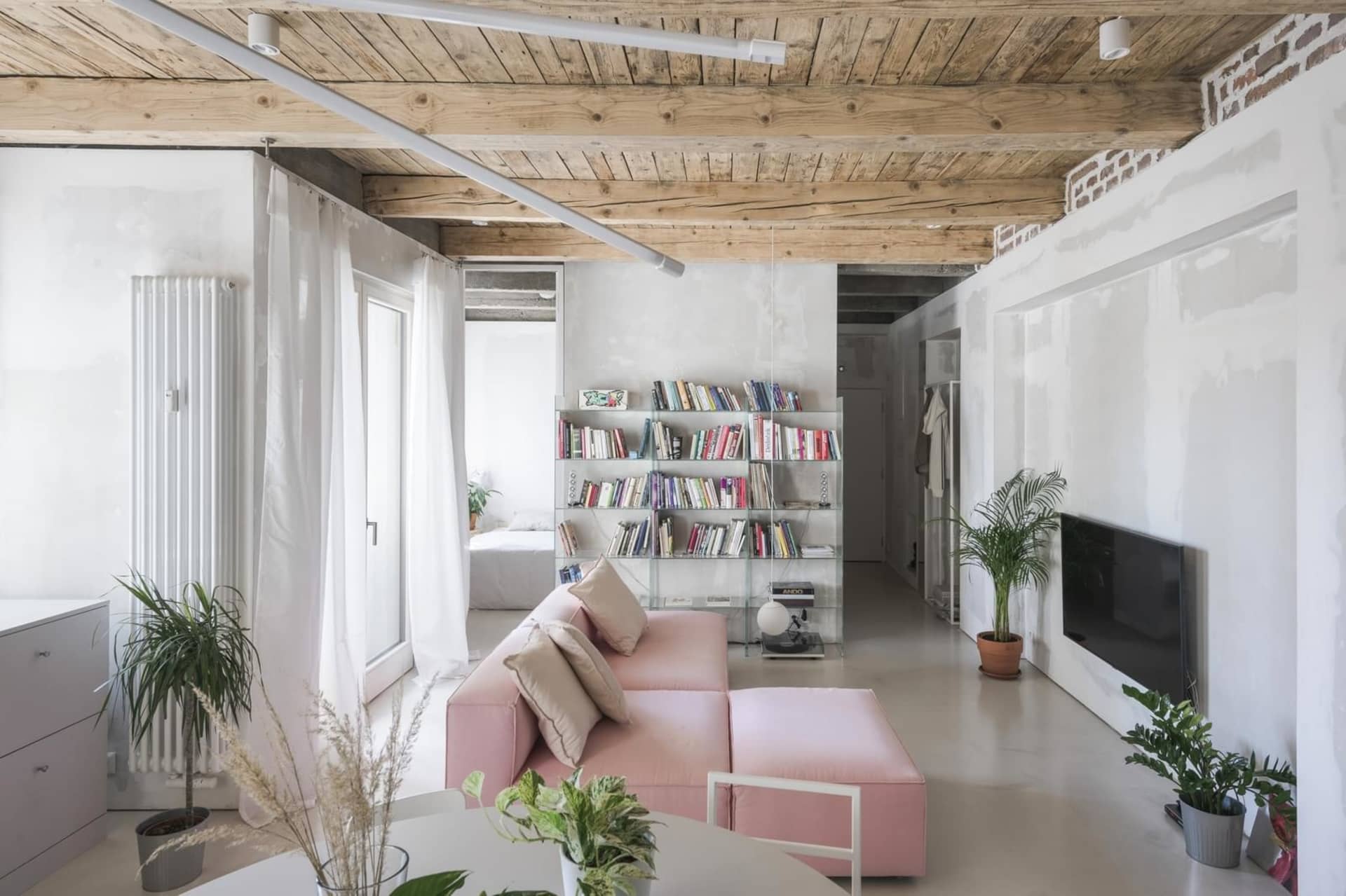 A minimalist living room with concrete, glass, and metal materials.