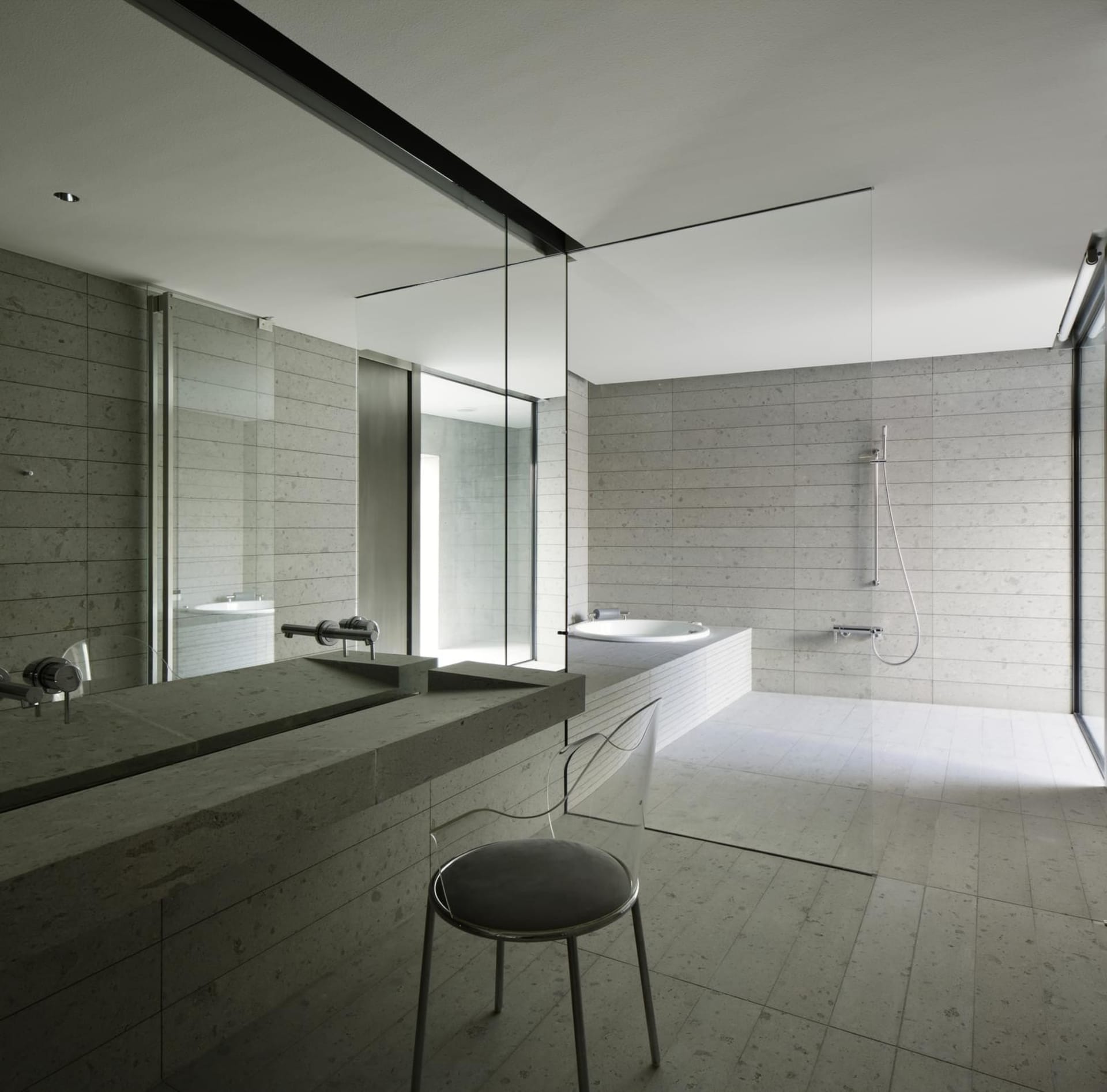 A modern bathroom featuring concrete walls and a stone countertop.