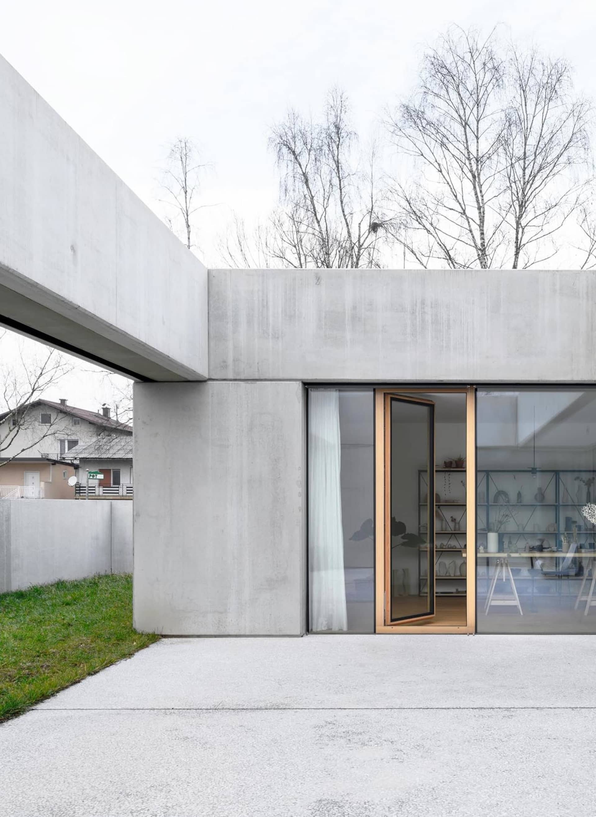 Concrete residential extension with glass windows and open floor plan.