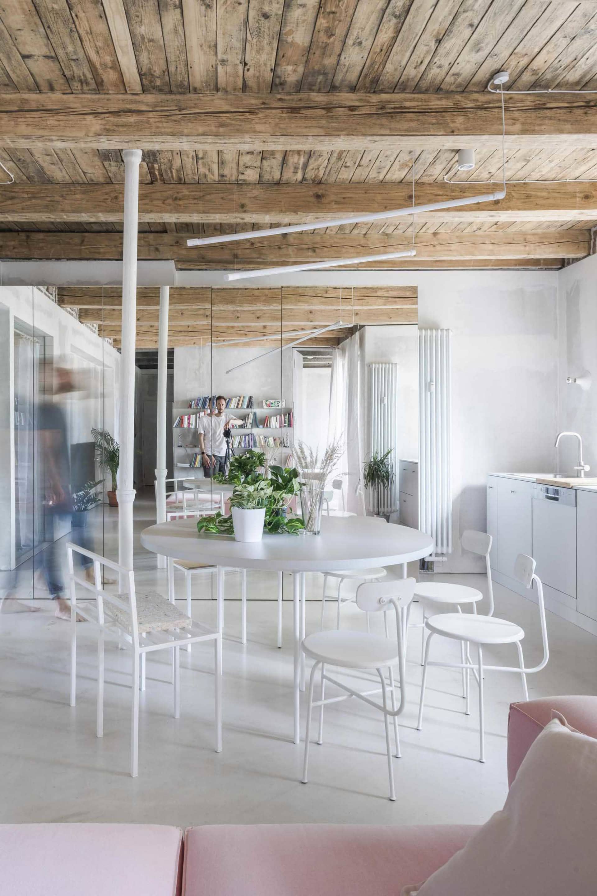 Living room with minimalist style, featuring white steel furniture and concrete floor.
