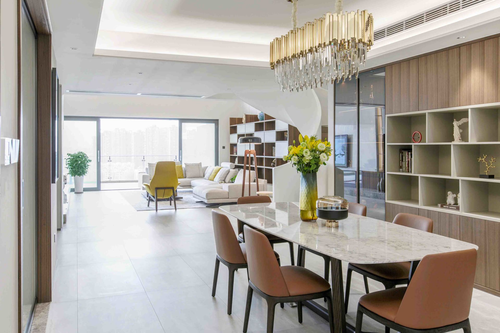 Modern living room with marble floor, glass windows, and wooden furniture.