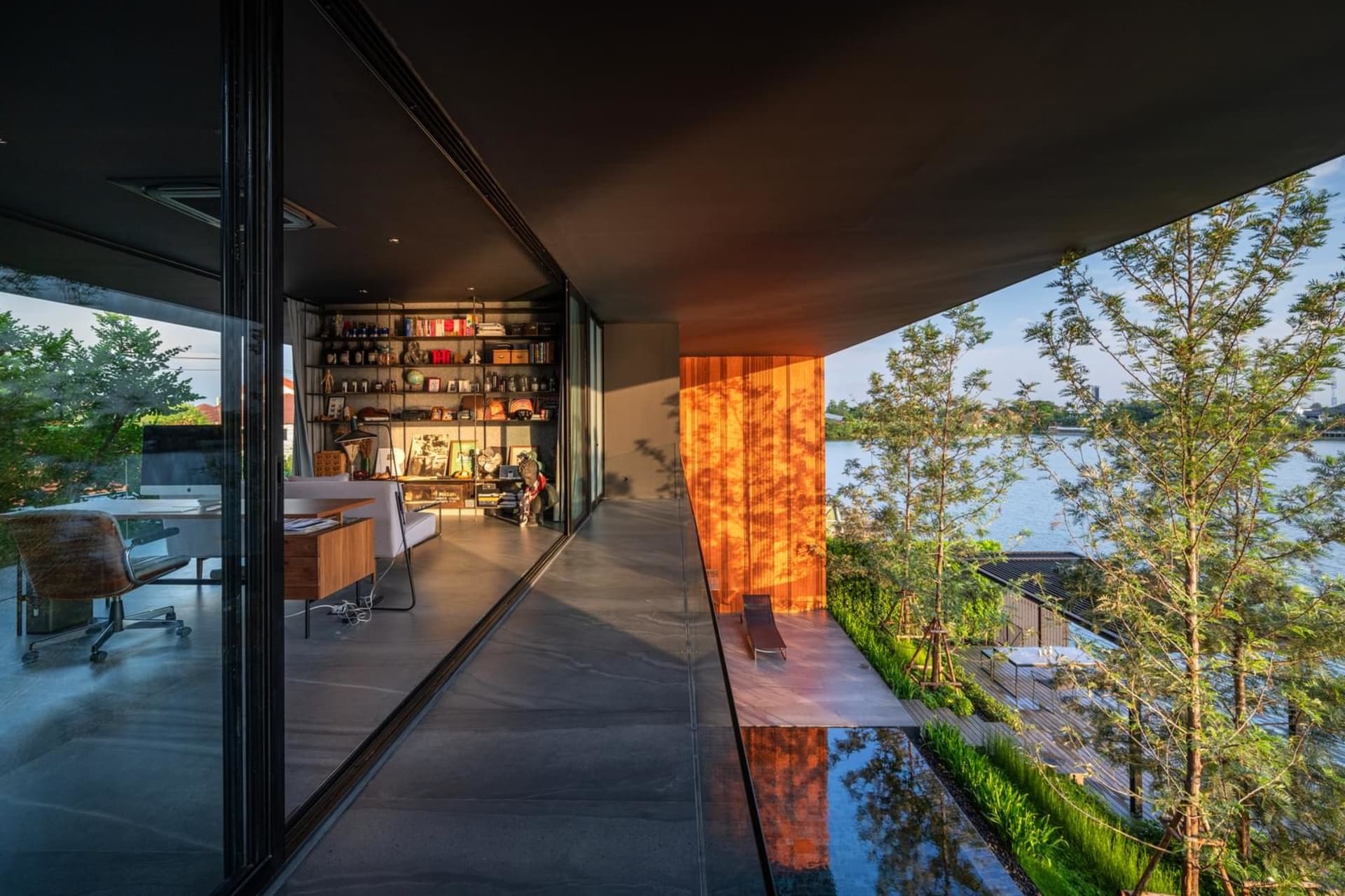 Modern office space featuring glass walls, concrete floor, and wooden accents.