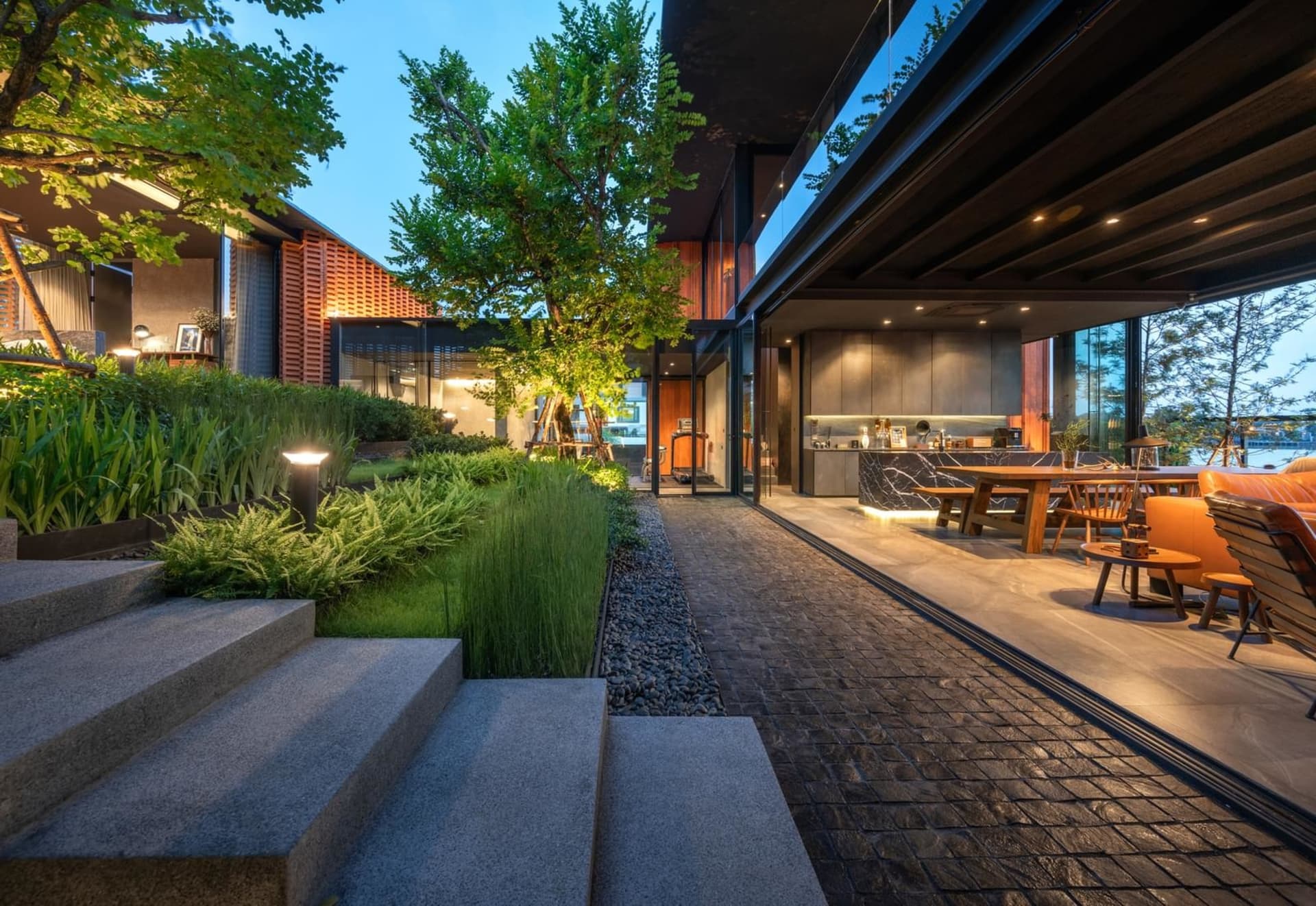 現代住宅戶外空間,設有景觀花園、混凝土階梯與綠意植栽。