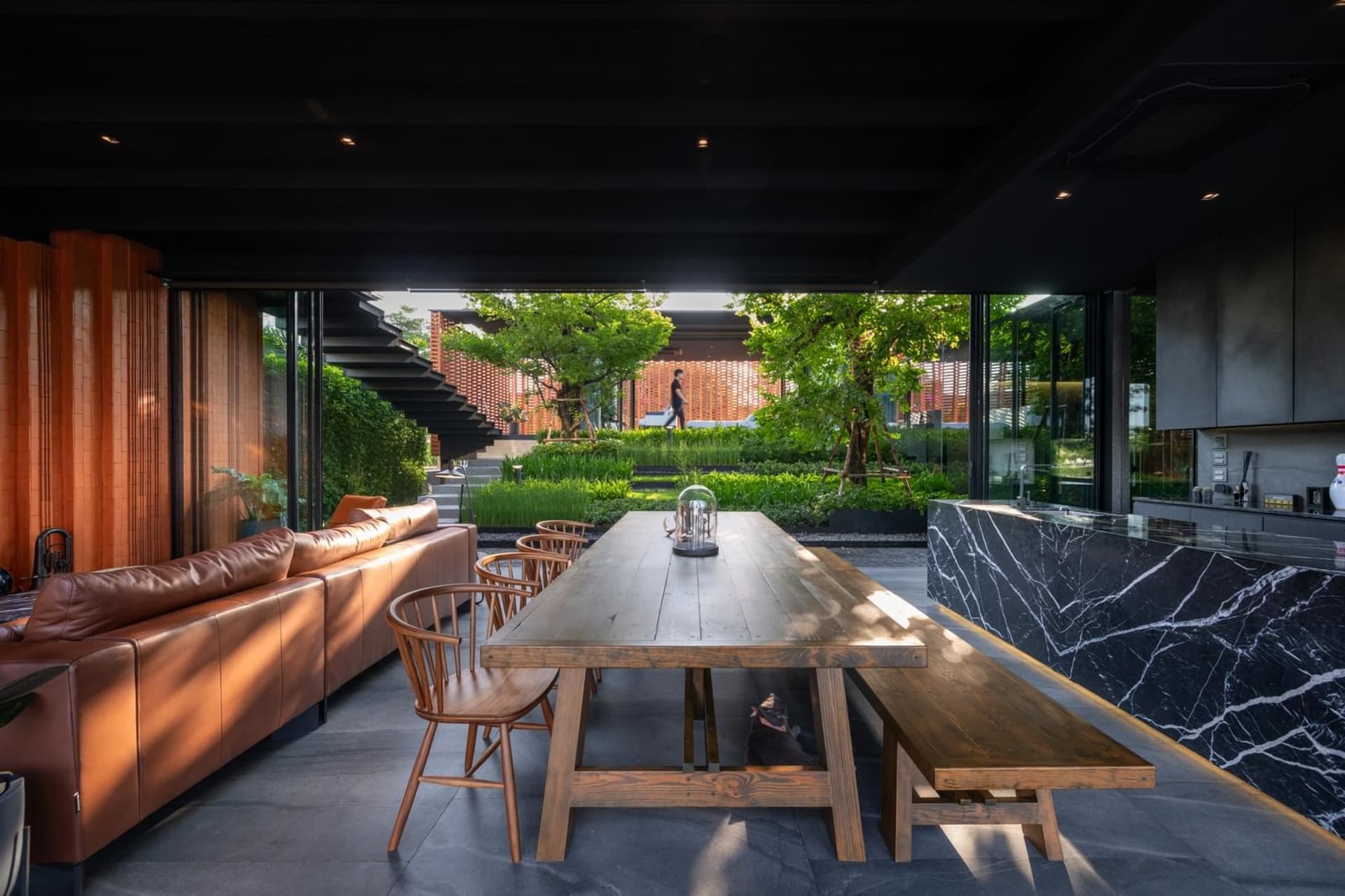 Industrial-style interior with wooden table, marble countertop, and glass panel wall.
