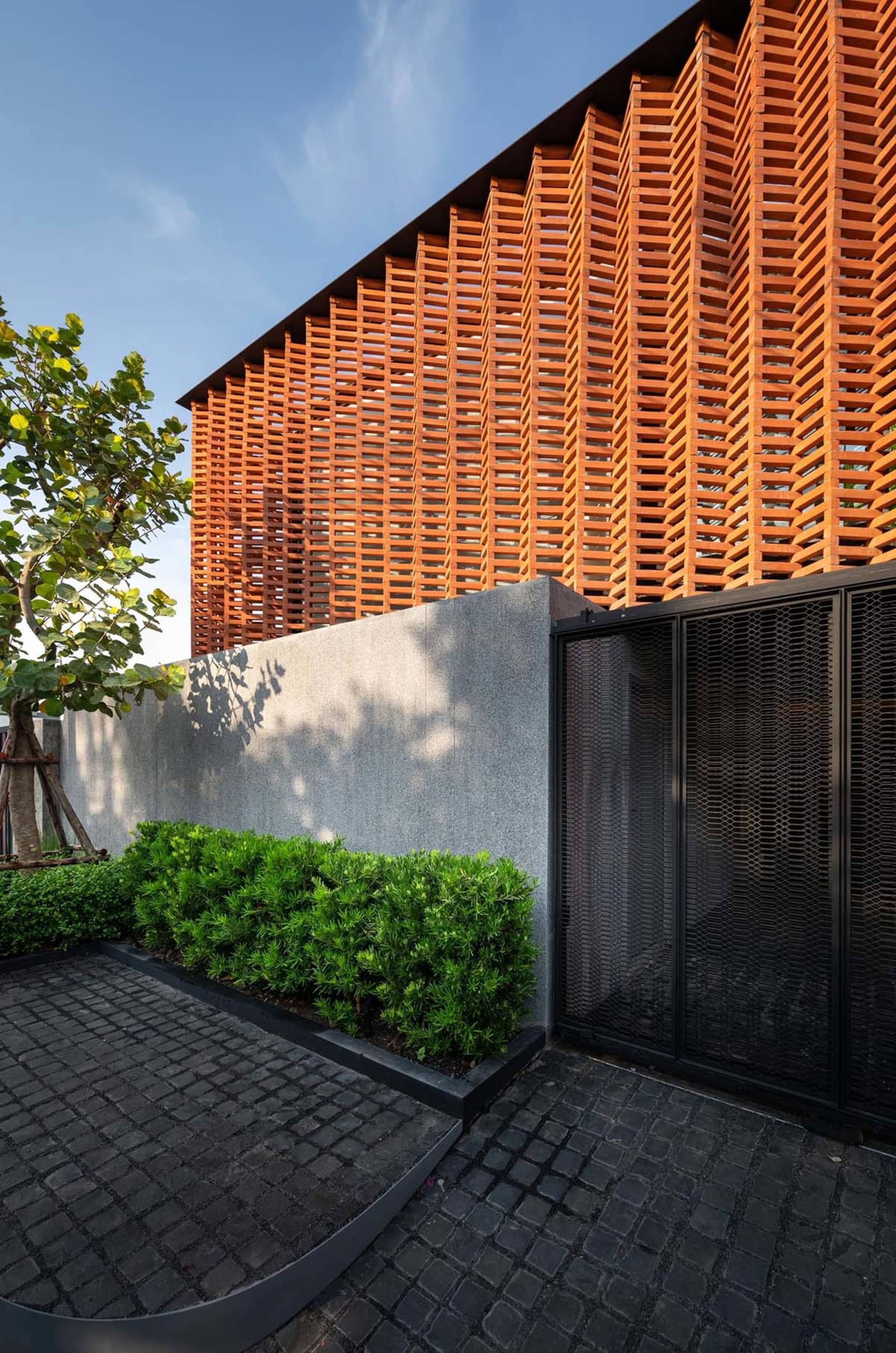 Modern architectural design featuring wooden lattice panels and concrete walls.