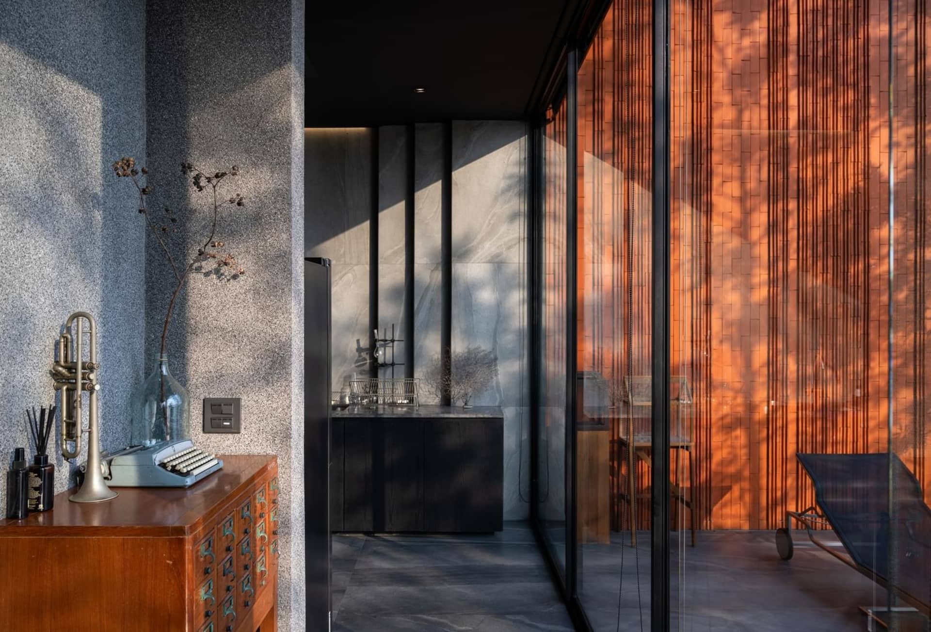 A modern residential balcony with glass panels and concrete flooring.