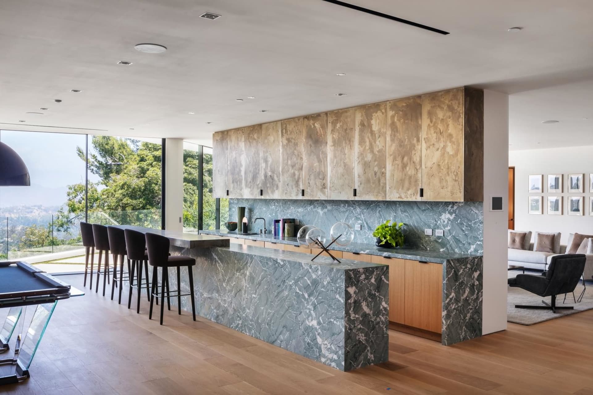 A modern kitchen with a marble island and ample seating.