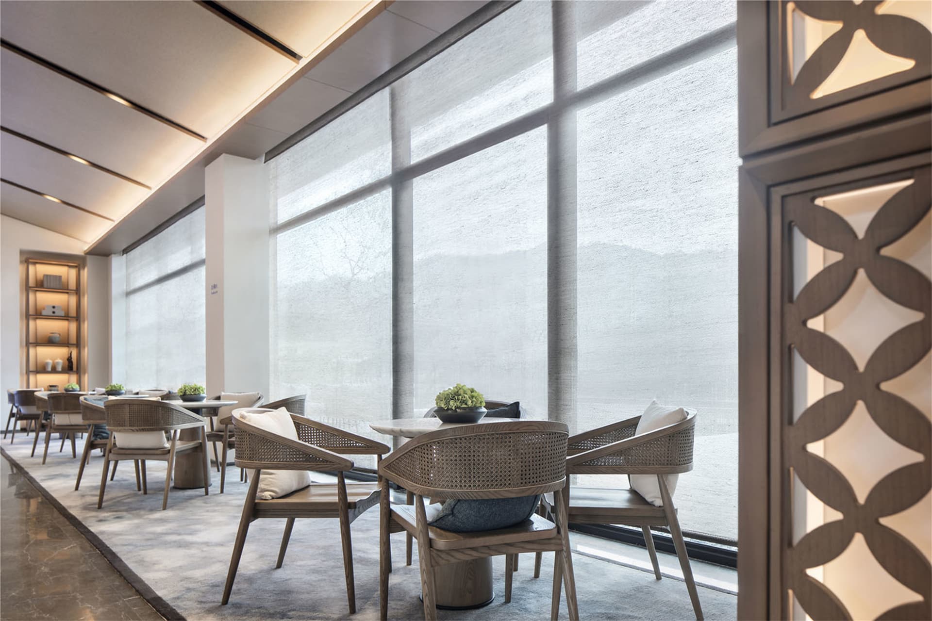 A modern cafeteria with fabric seating and wooden tables.