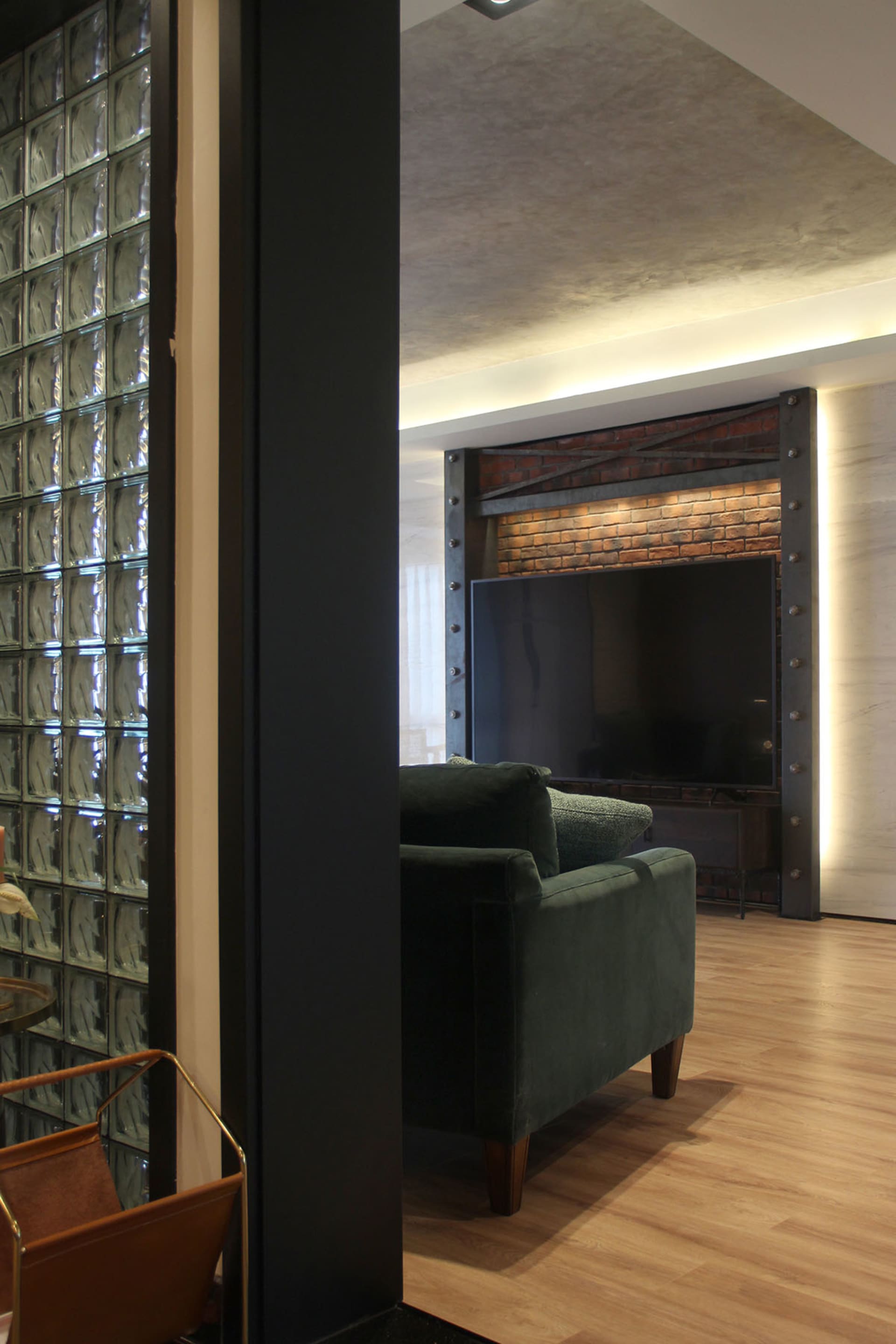 A modern industrial living room with a concrete floor, exposed brick walls, and steel accents.
