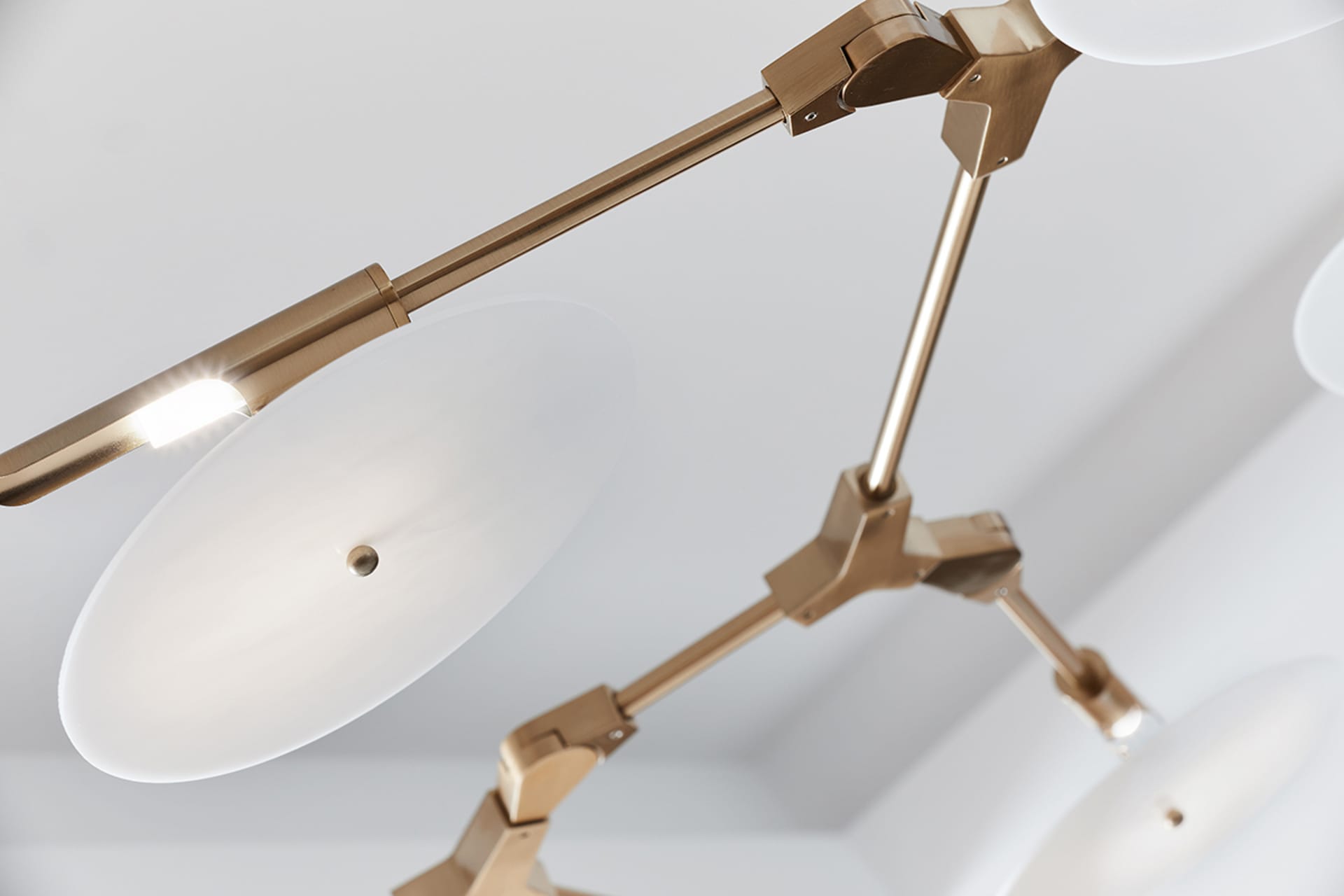 Close-up of modern lighting fixture with metallic and glass elements.