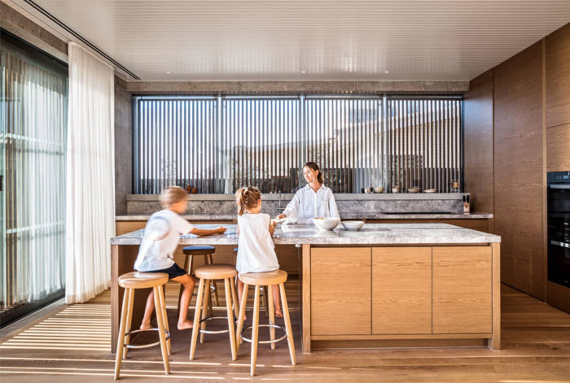 Modern kitchen with family sitting at wooden counter