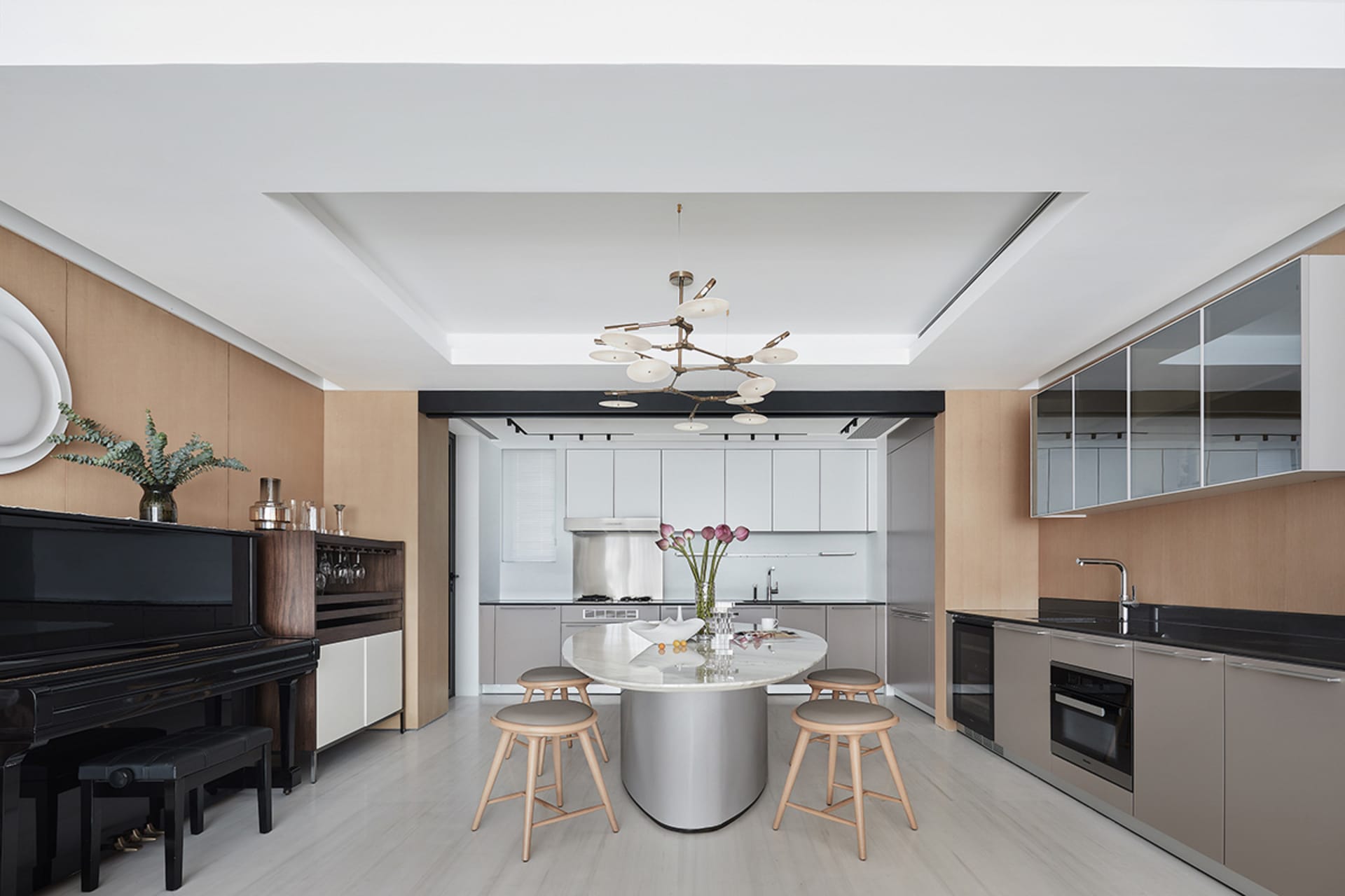 A modern kitchen with marble countertops and stools.