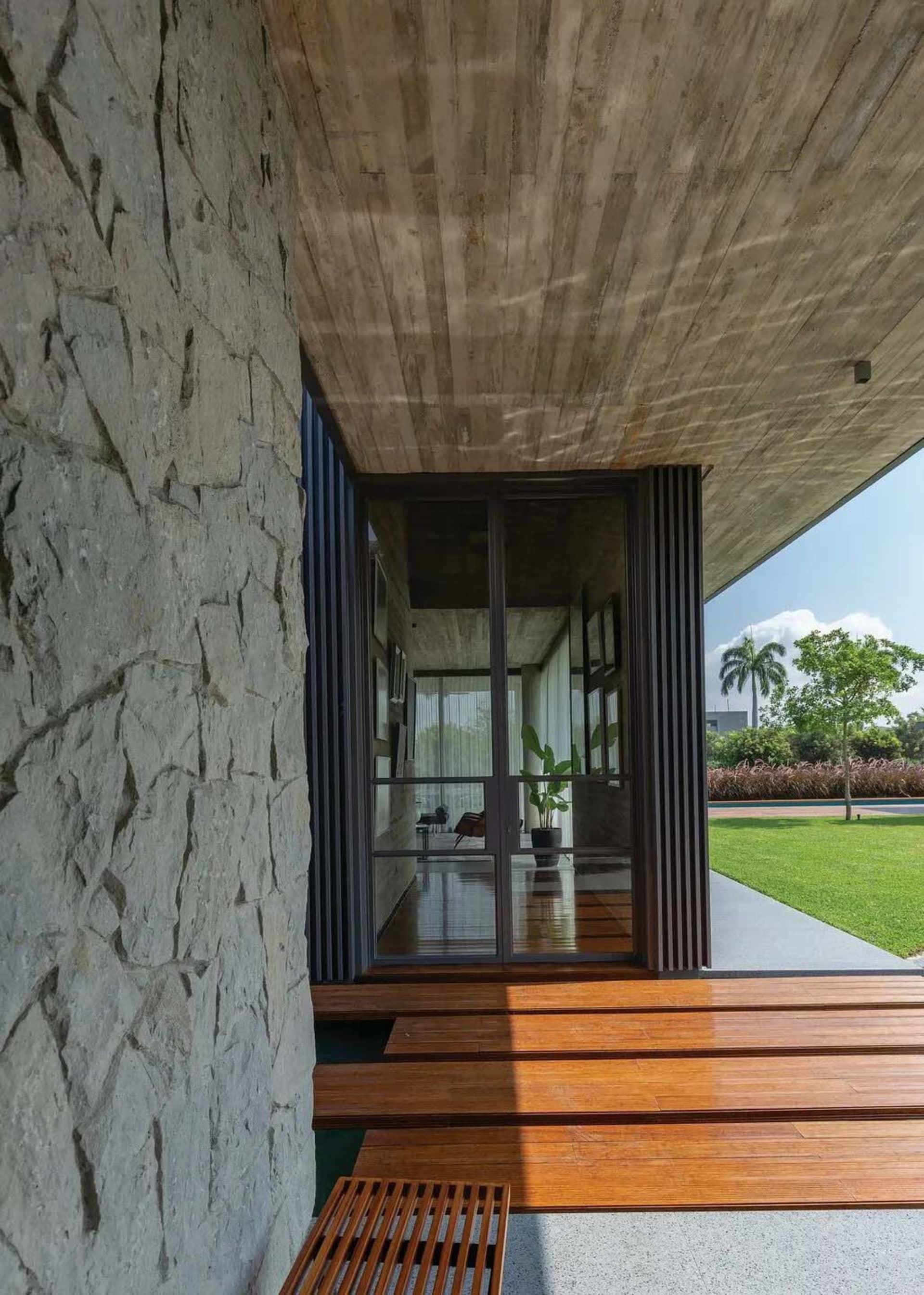 A modern entranceway featuring a concrete wall, composite material walls, and wooden flooring.
