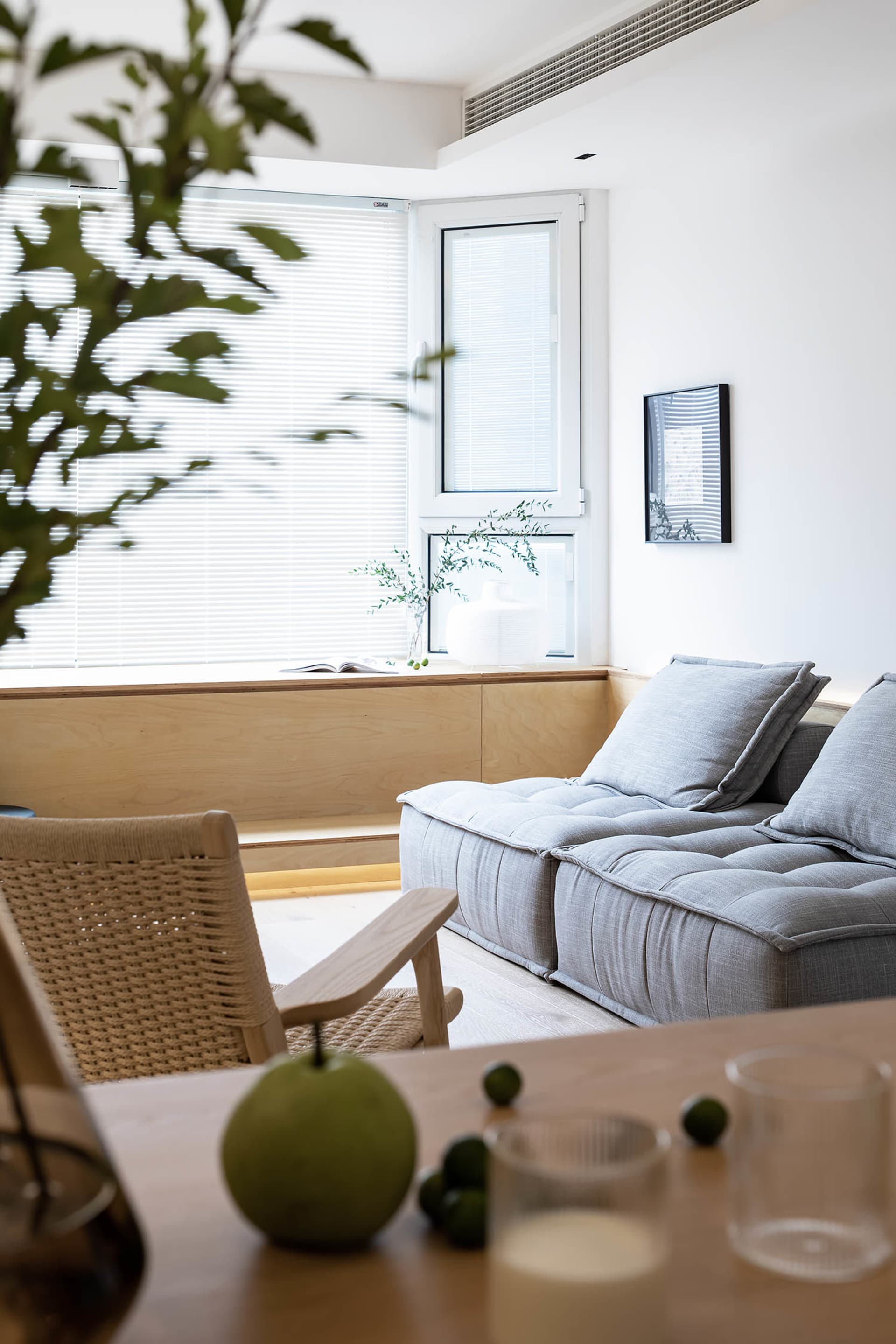 Modern minimalist living room featuring neutral-toned fabric cushions on a low-profile sofa.