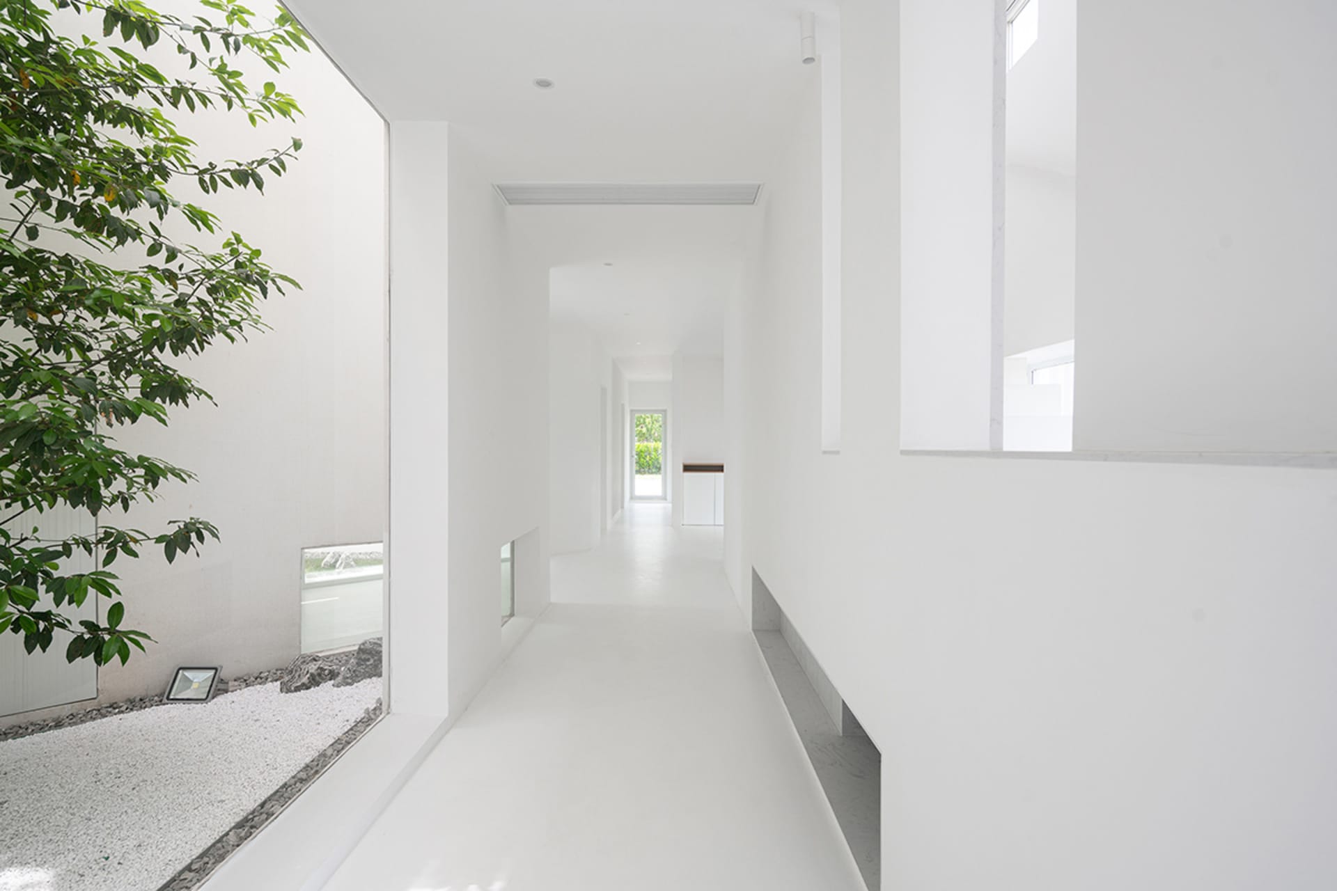 極簡白色室內空間，混凝土牆面與地板，搭配現代建築元素，乾淨開闊的設計