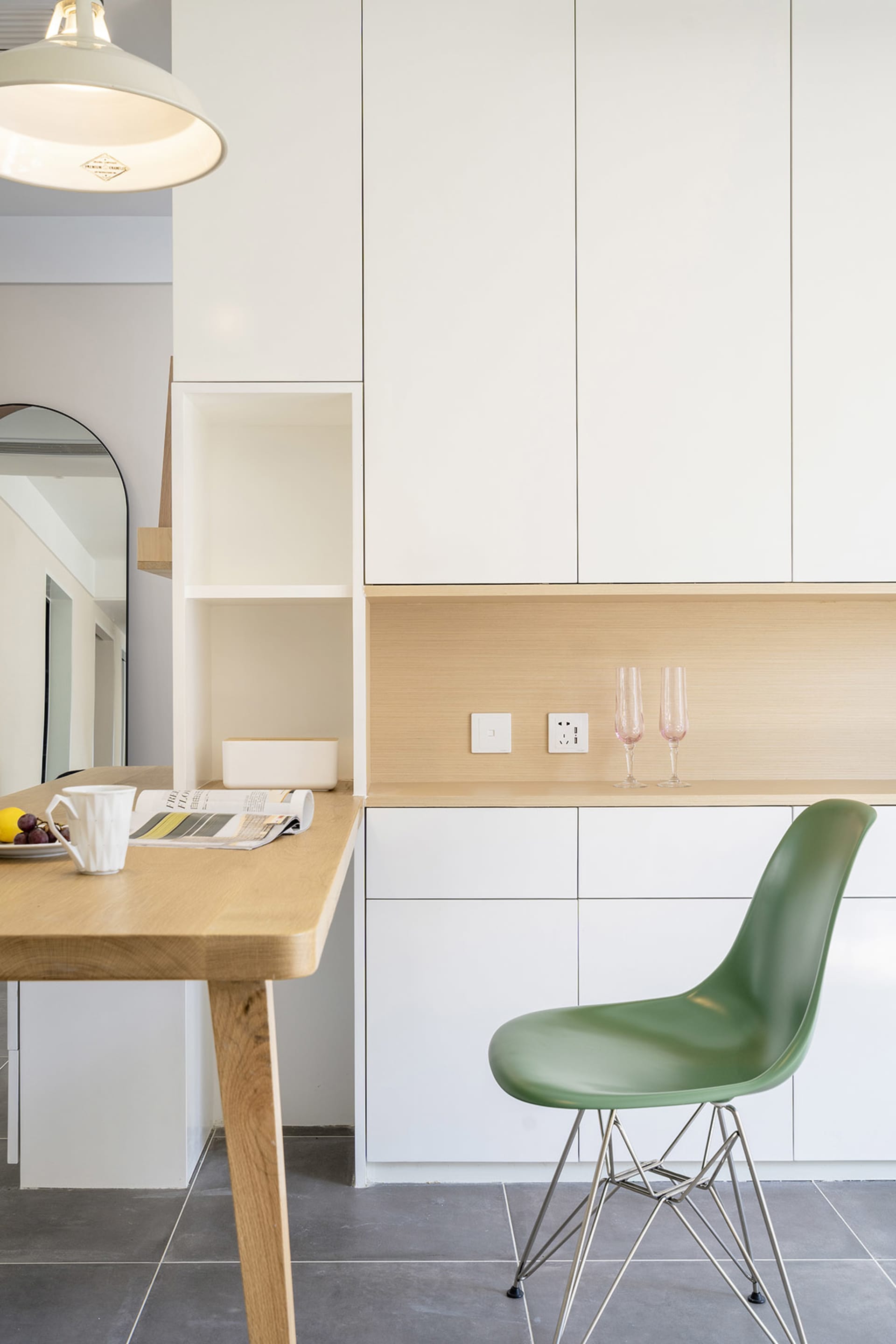 A modern white kitchen with wooden furniture and white cabinets.