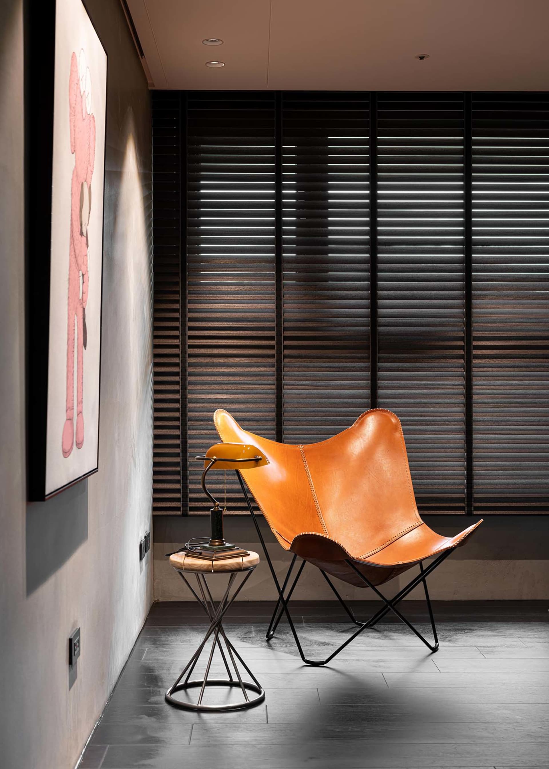 A minimalist living room featuring a modern leather butterfly chair with metal legs.