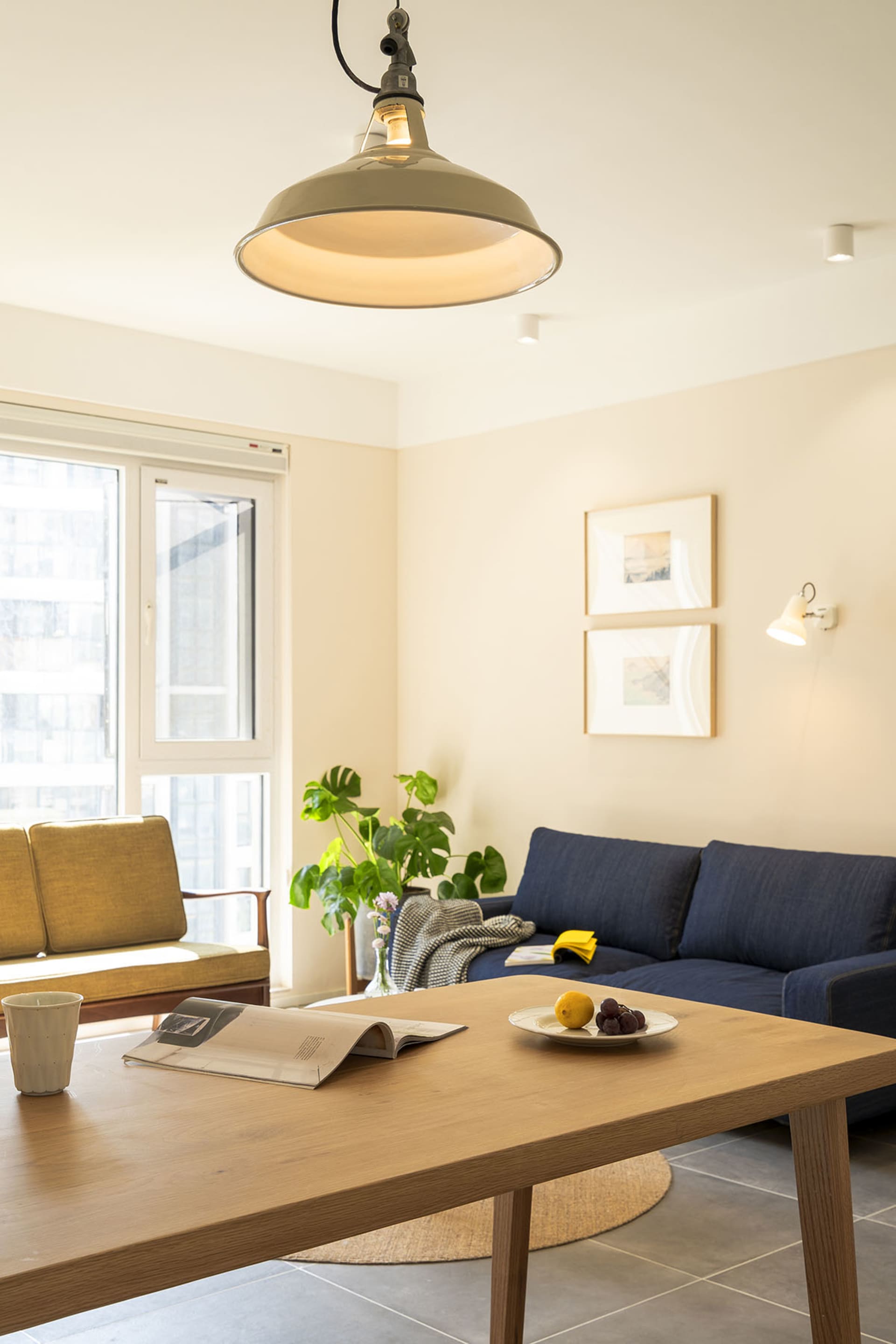 Modern, minimalist living room with wooden furniture, fabric upholstery, and metal accents.