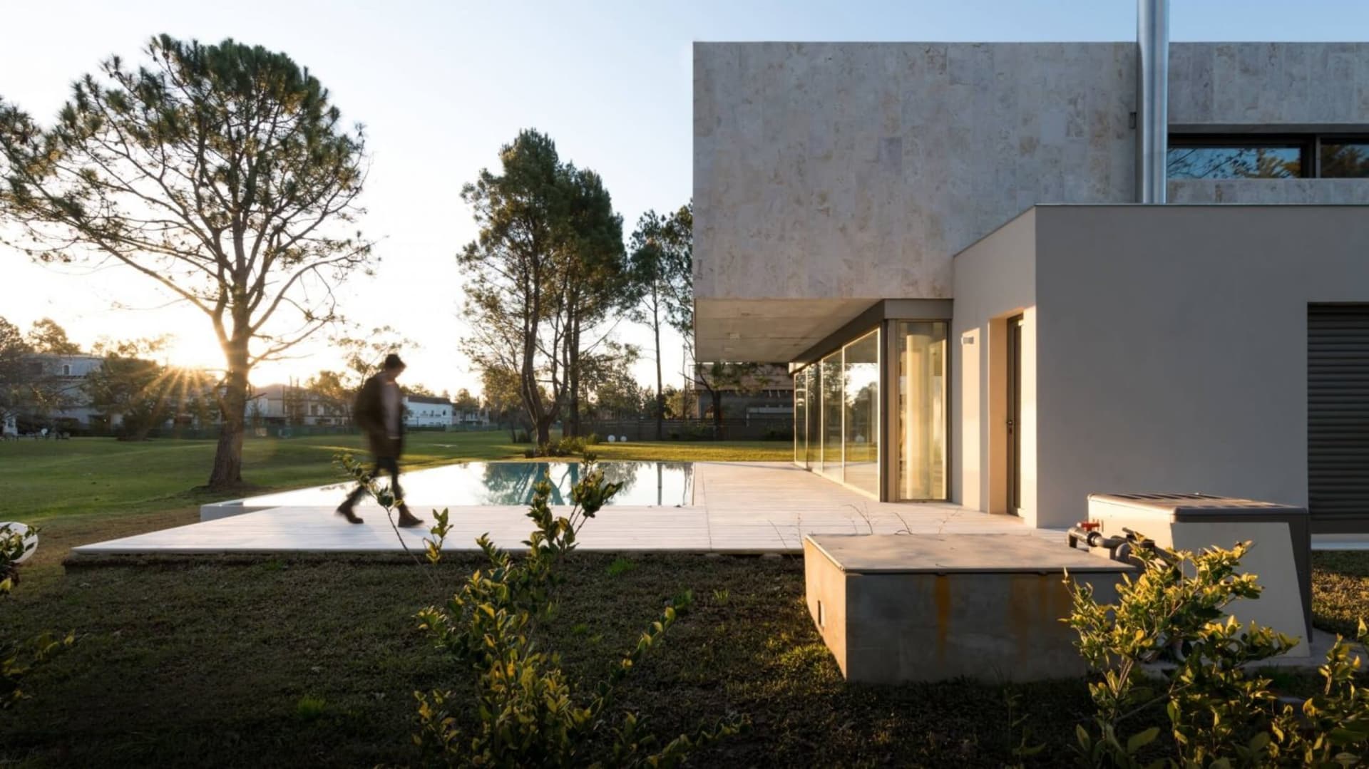 Modern house featuring concrete and glass exterior with a poolside setting.