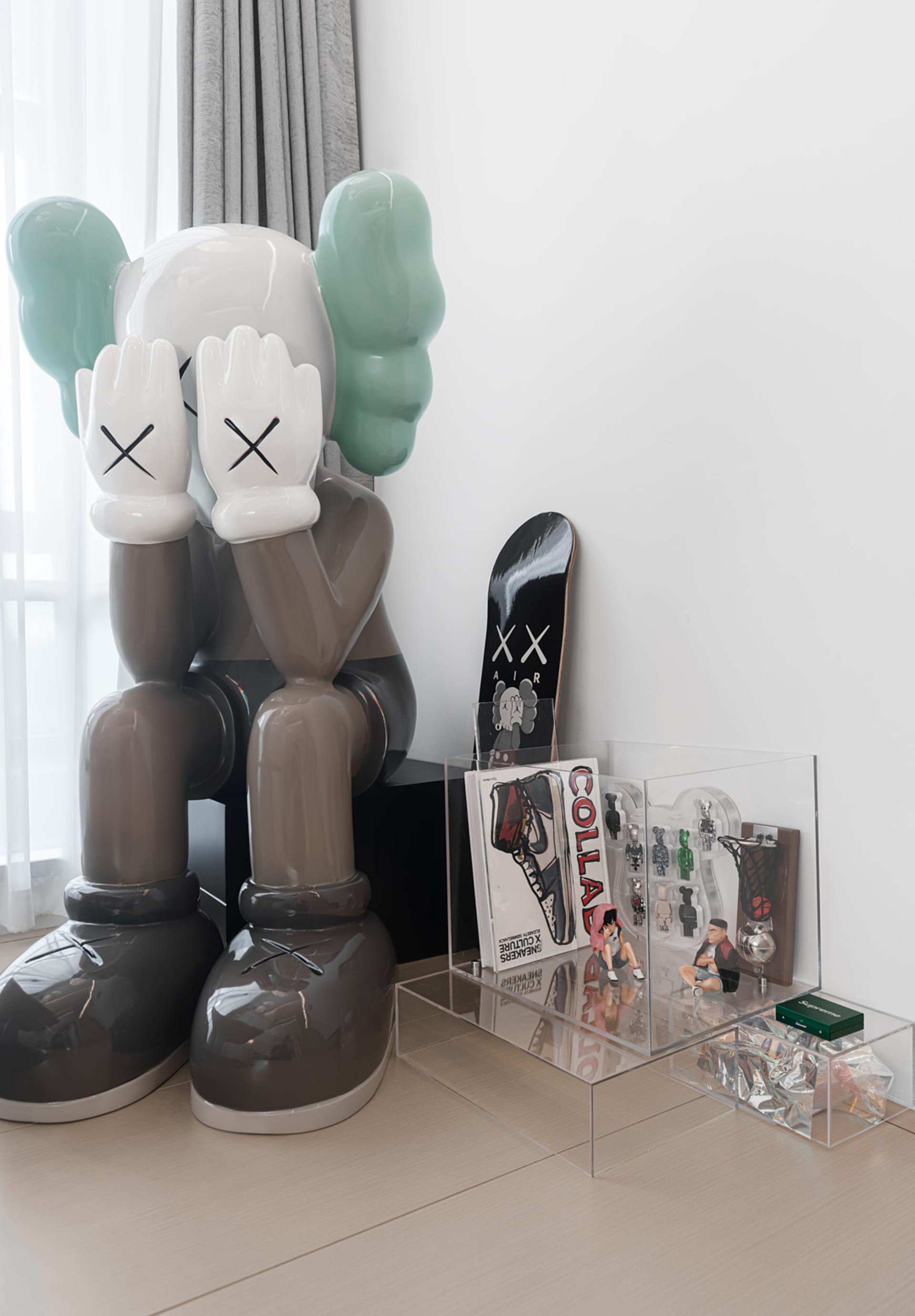 A minimalist room featuring a modern interior design artwork with a pair of large, oversized shoes in grey and teal, alongsid