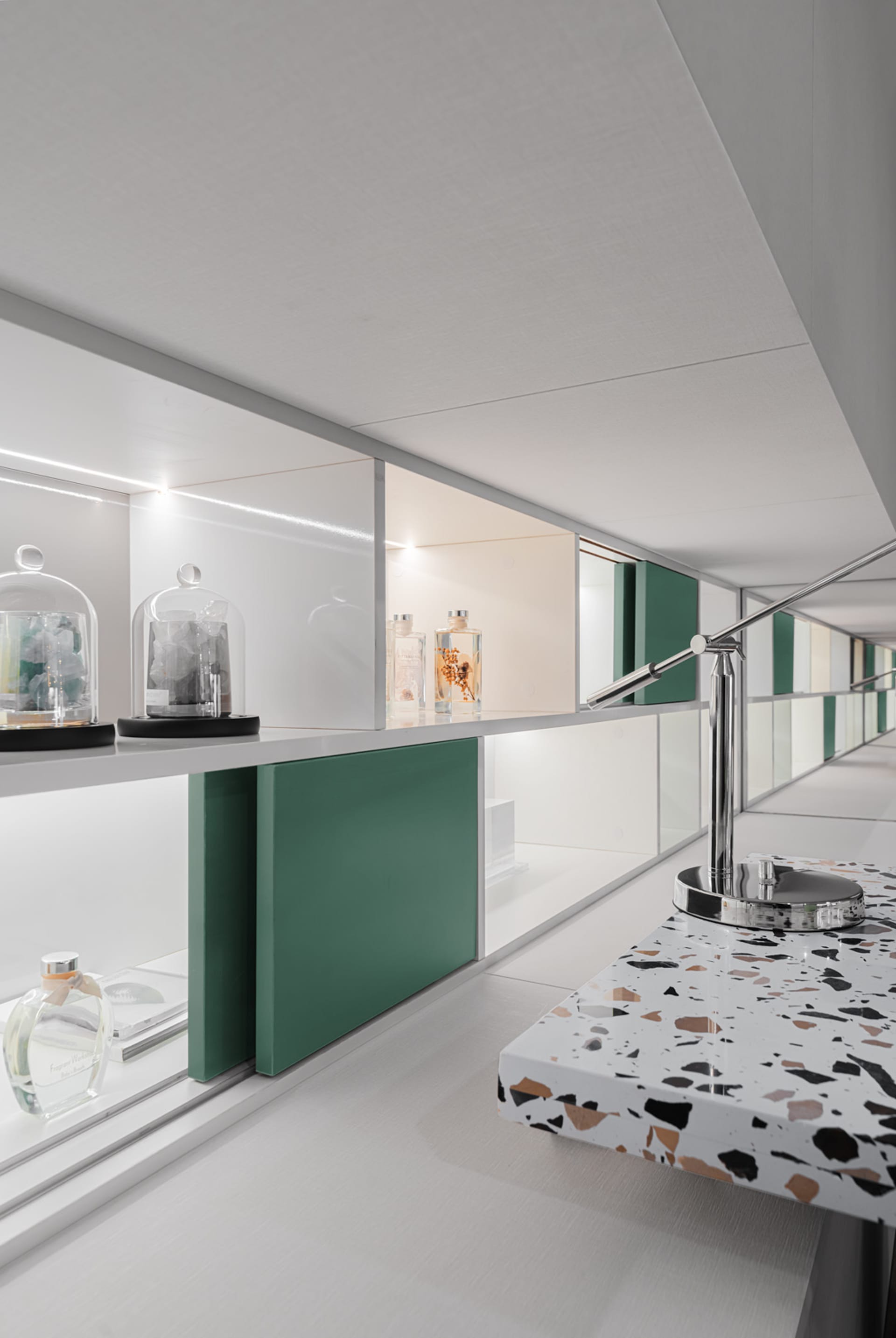 Modern showroom with glass cabinets, marble surfaces, and metallic accents.