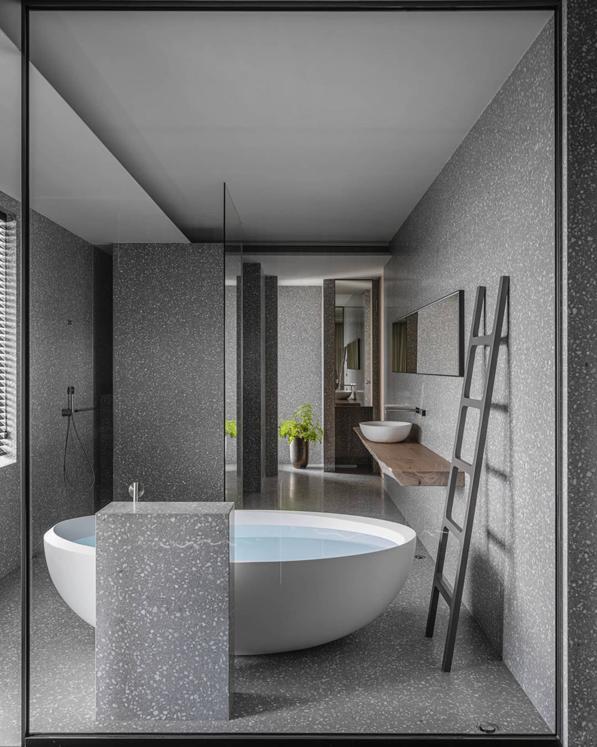 A minimalistic bathroom with a freestanding bathtub made of terrazzo